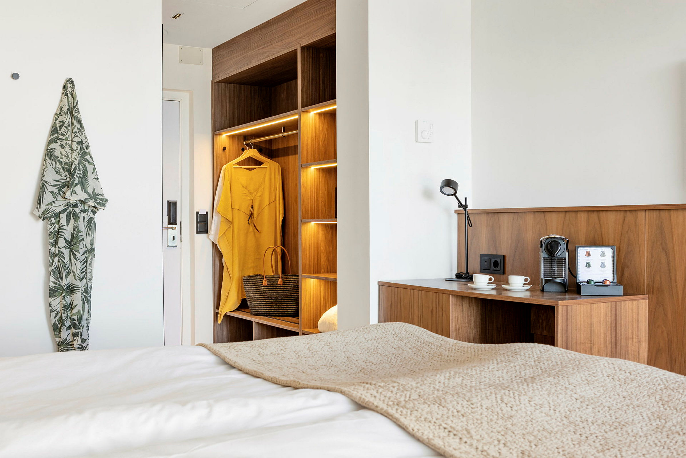 Moderne hotelværelse med træindretning, kaffestation og belysning. (AI-genereret tekst)
