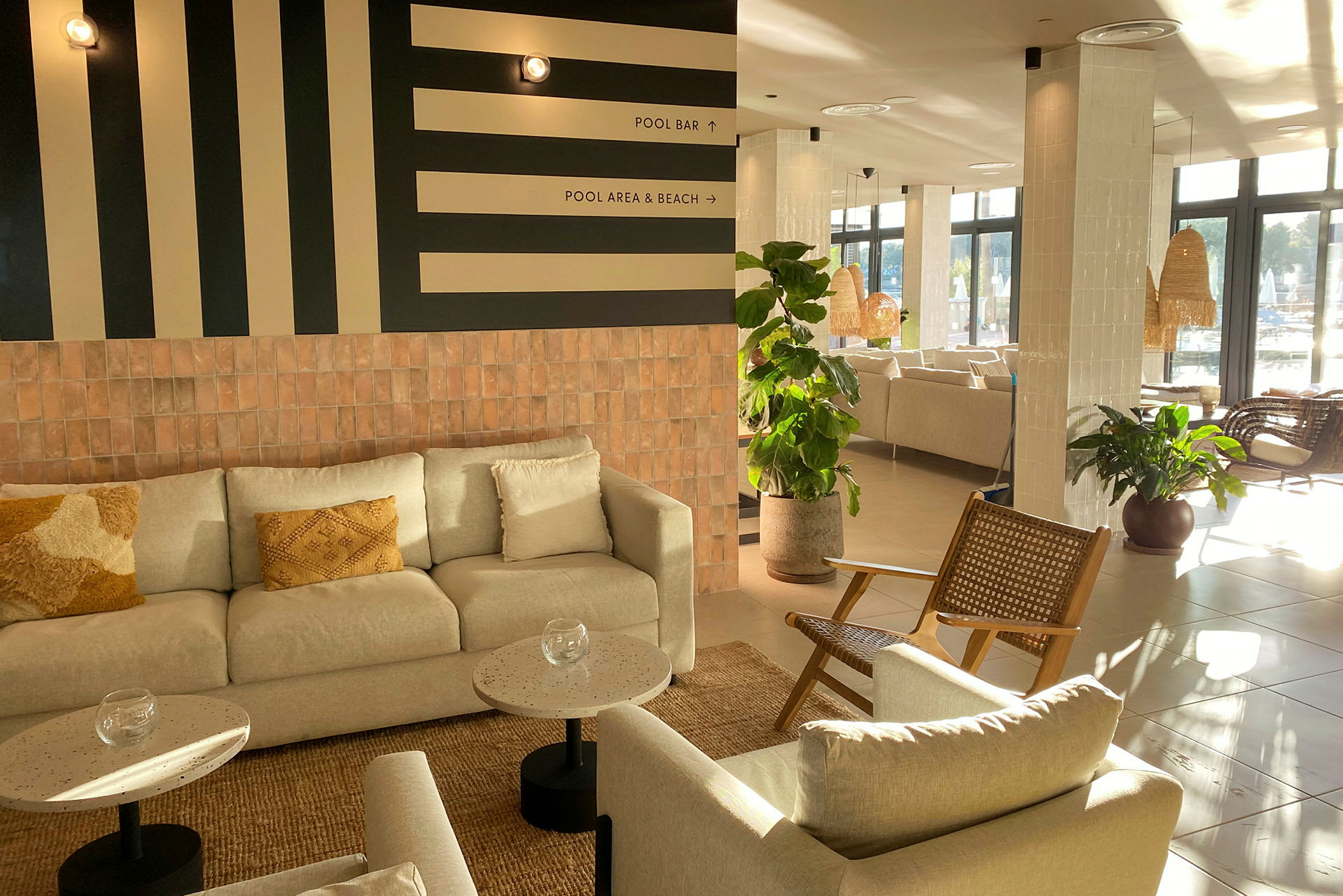 Billede af en lys og moderne lobby med sofagruppe og grønne planter. (AI-genereret tekst)