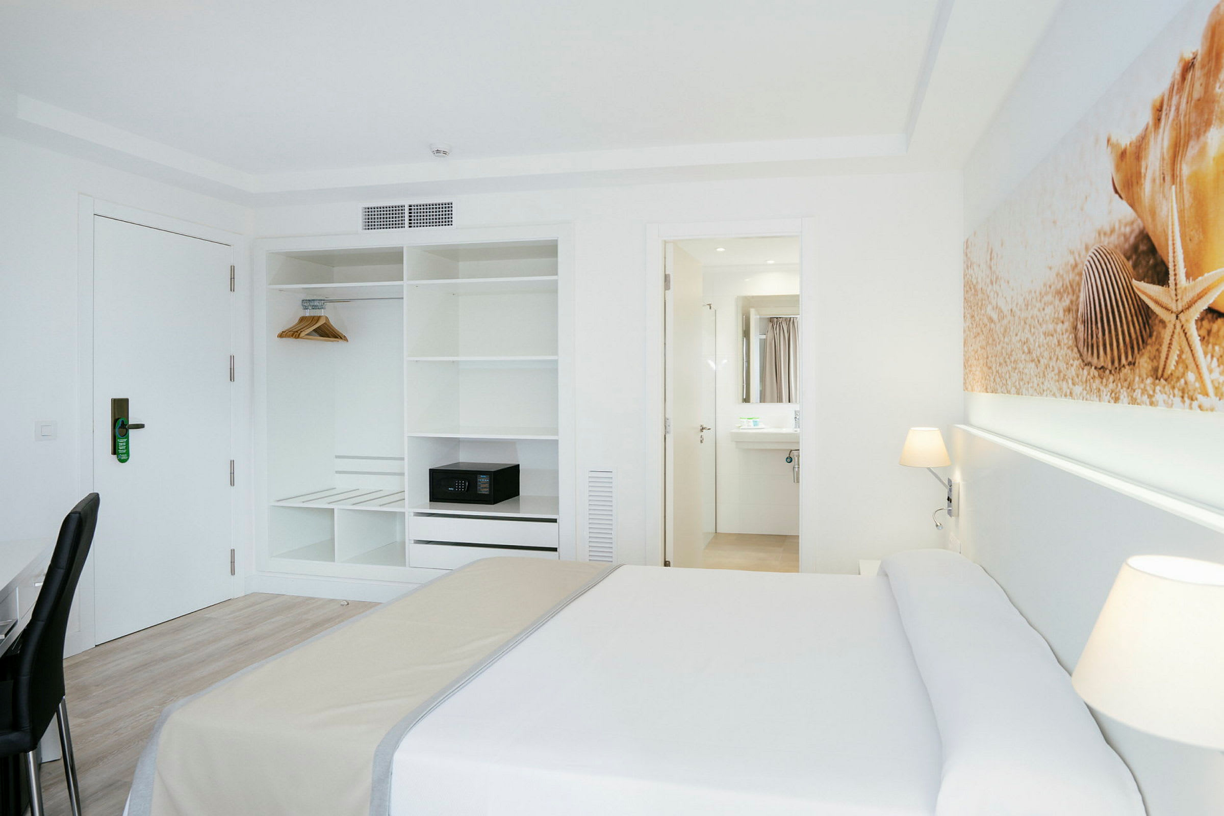 Hotelværelse med seng, garderobe og indgang til et badeværelse. (AI-genereret tekst)