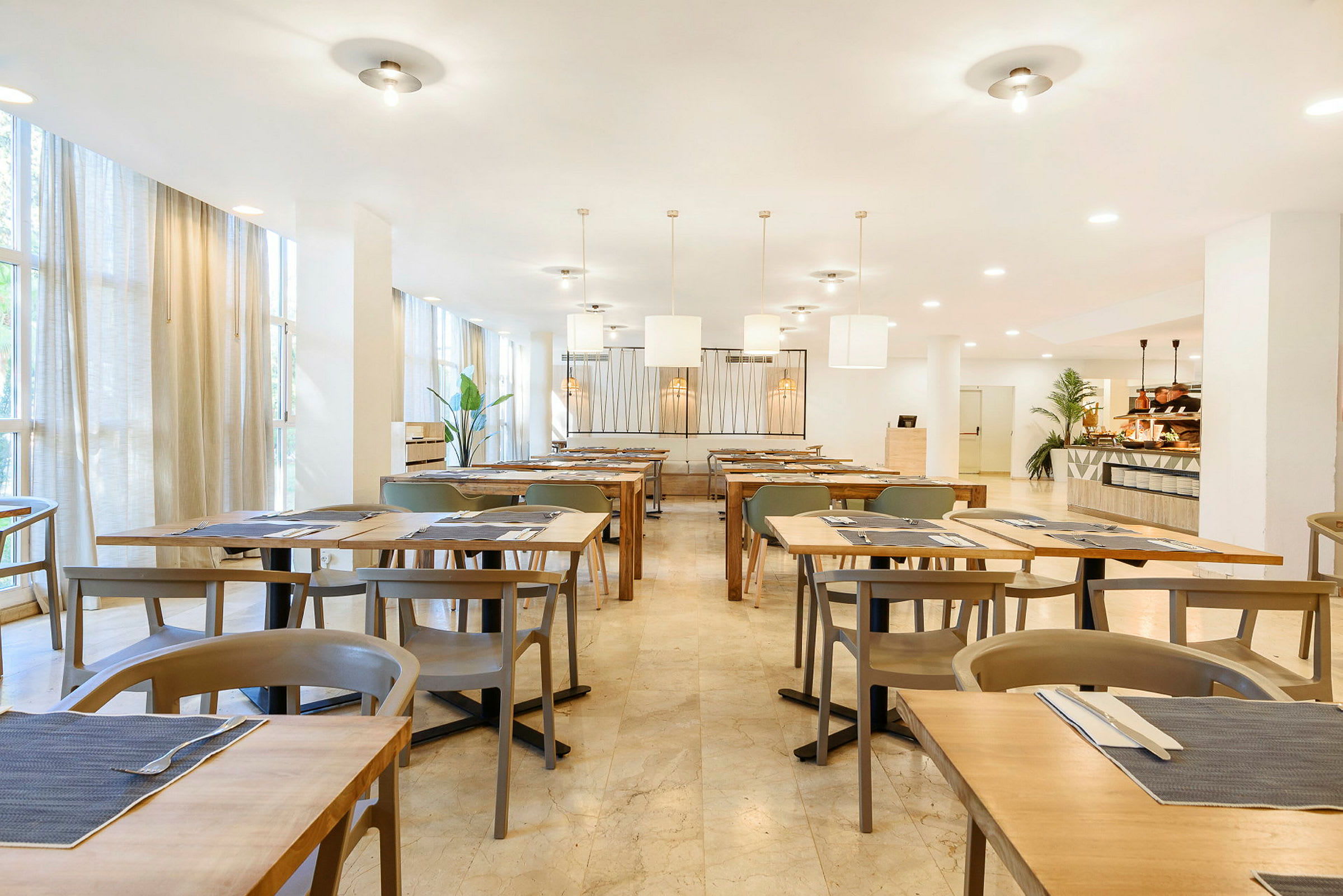 En lyst indrettet restaurant med opstillet borde og stole. (AI-genereret tekst)
