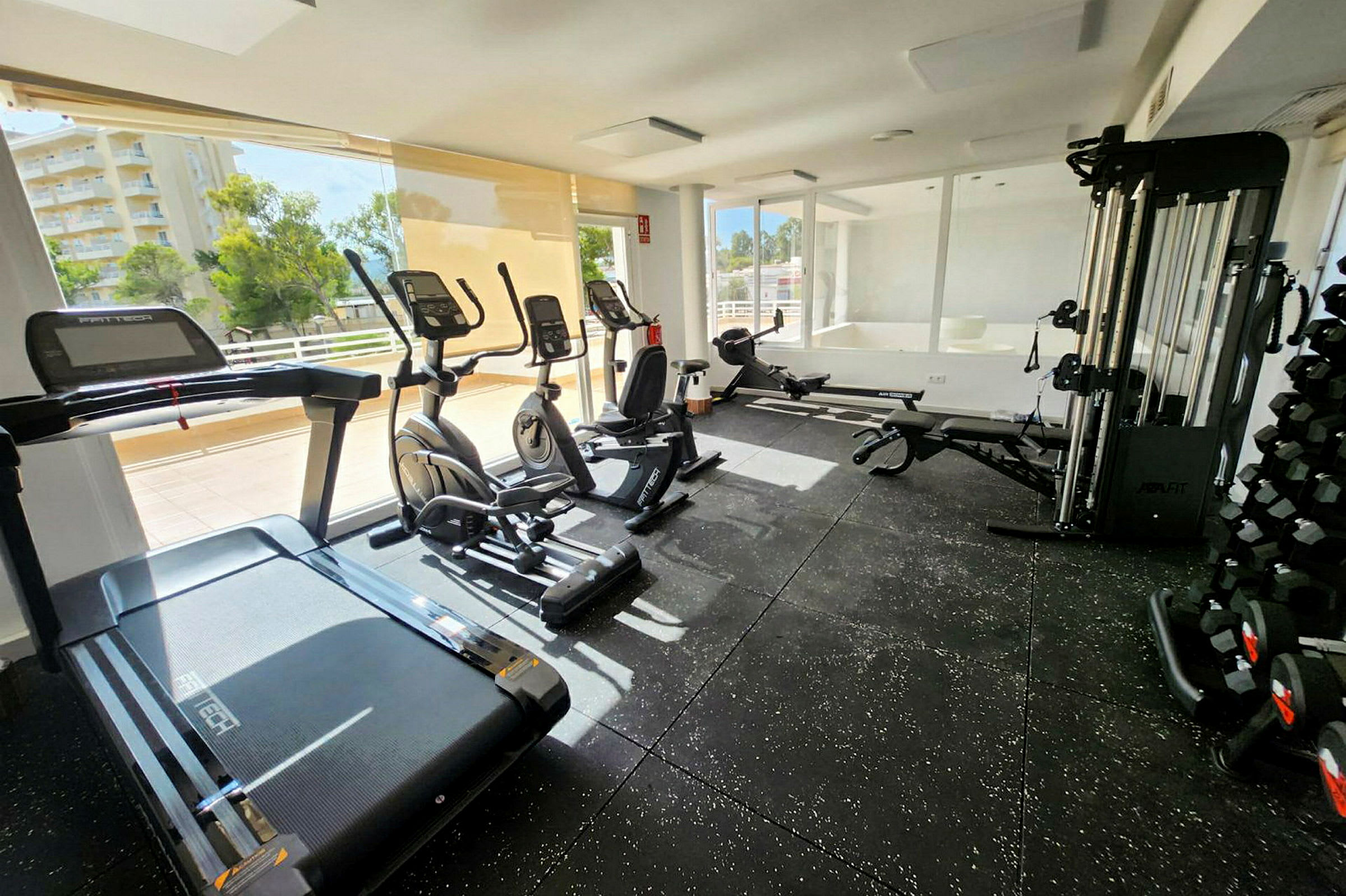 Et fitnesscenter med træningsudstyr inklusive løbebånd, elliptiske trænere og vægte. (AI-genereret tekst)