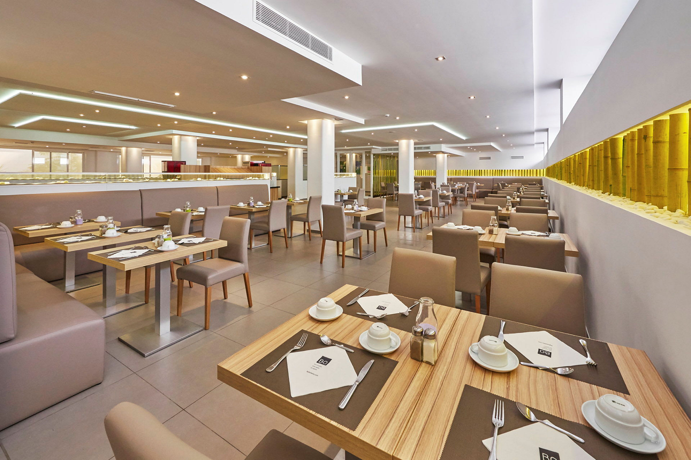 En moderne restaurant med dækkede borde og komfortable stole. (AI-genereret tekst)