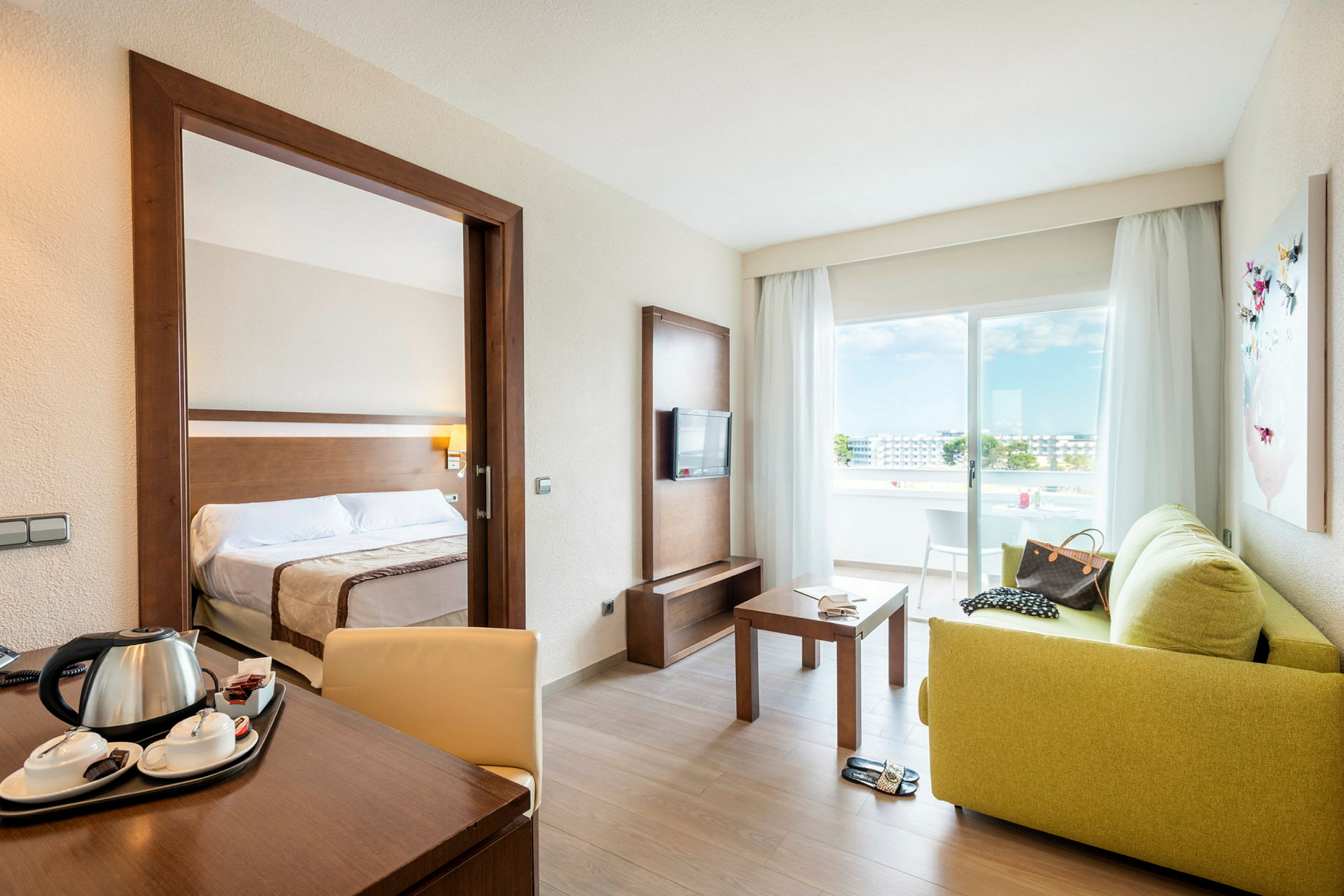 Hotelværelse med separat soveværelse, siddeområde, balkon og udsigt. (AI-genereret tekst)