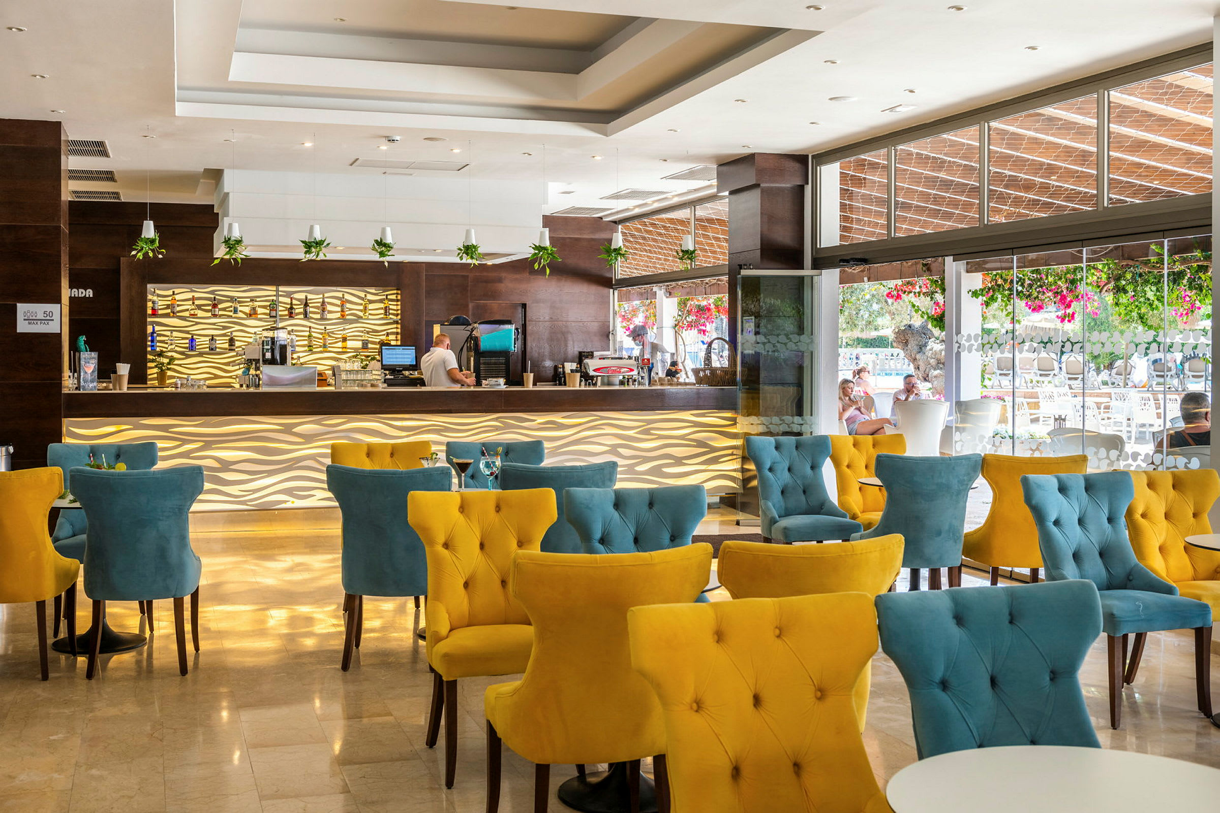 En moderne hotelbar med farverige stole og dekorative belysningsdetaljer. (AI-genereret tekst)