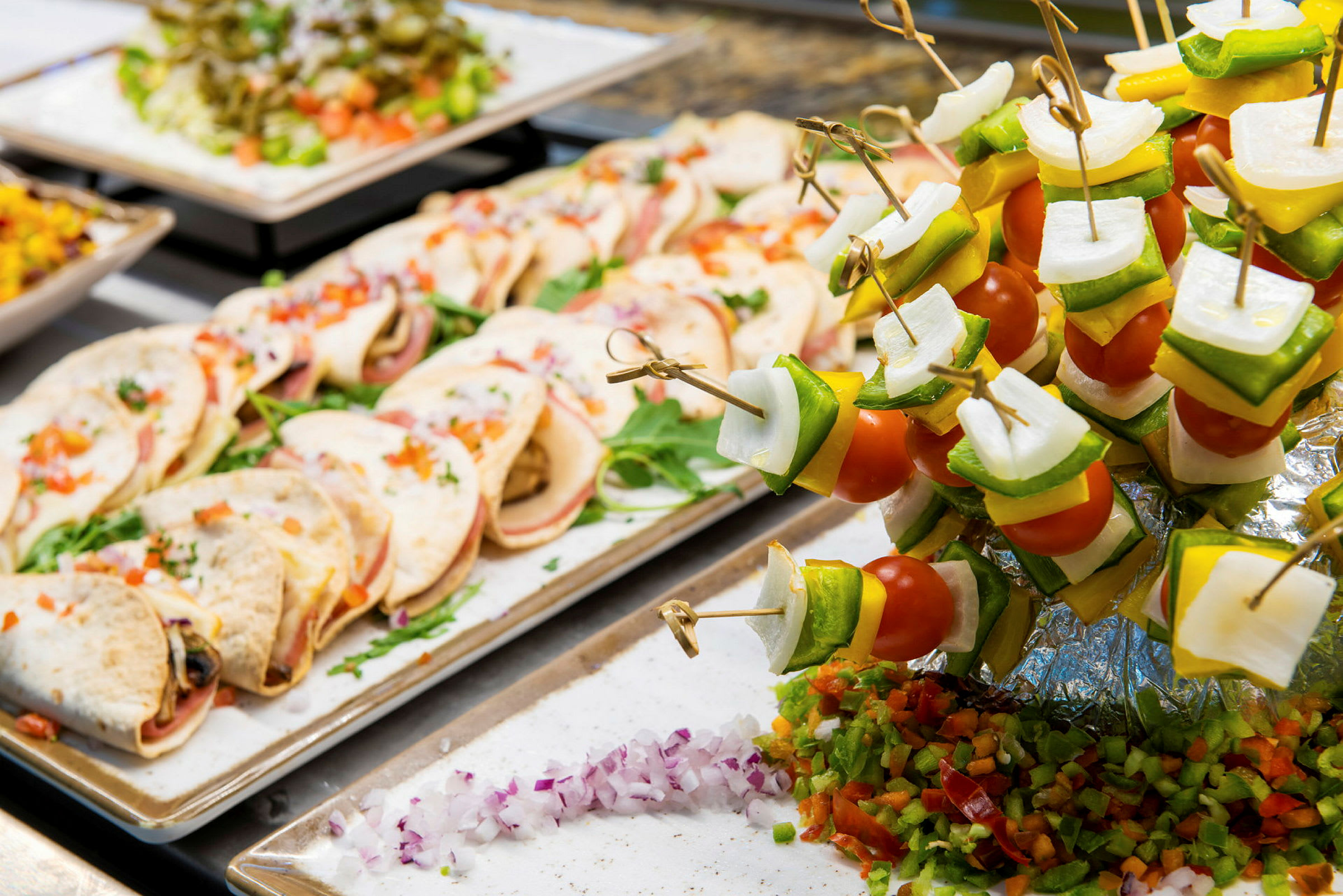 Buffet med små tortillas og farverige grøntsagsspyd. (AI-genereret tekst)