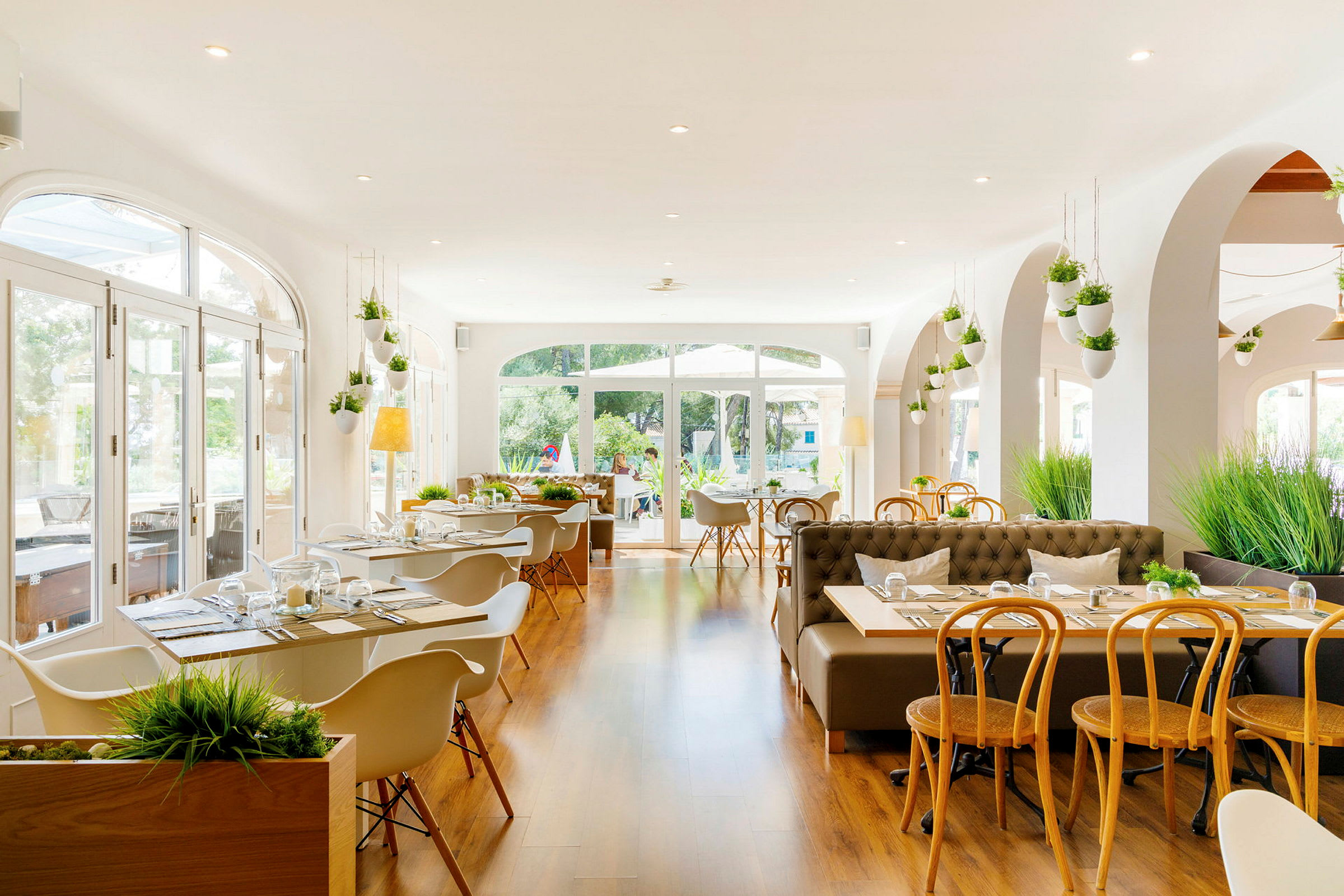En lys og moderne restaurant med store vinduer og træindretning. (AI-genereret tekst)