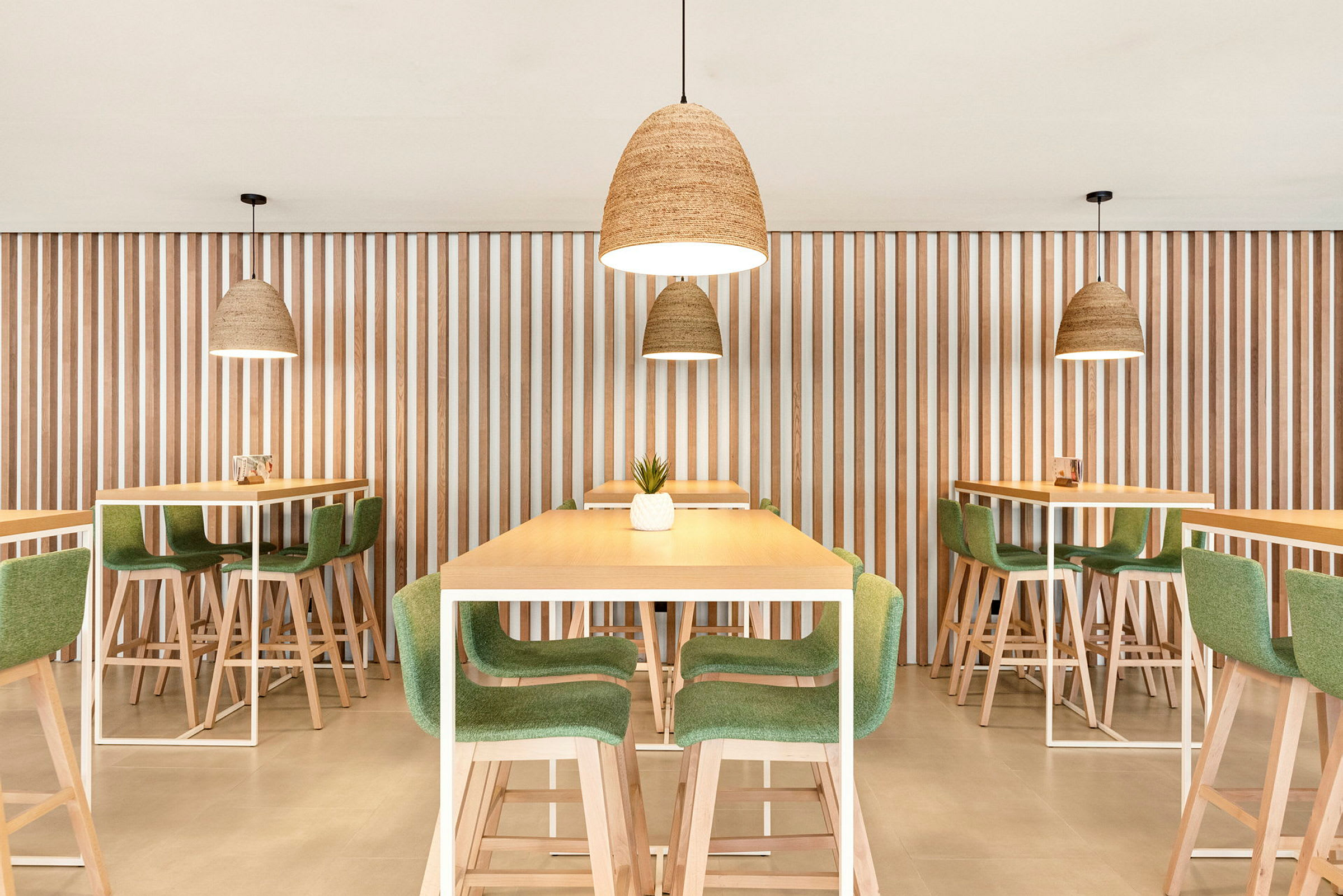 Billede af moderne restaurantinteriør med borde og stole i træ og grønt, og hængende lamper. (AI-genereret tekst)