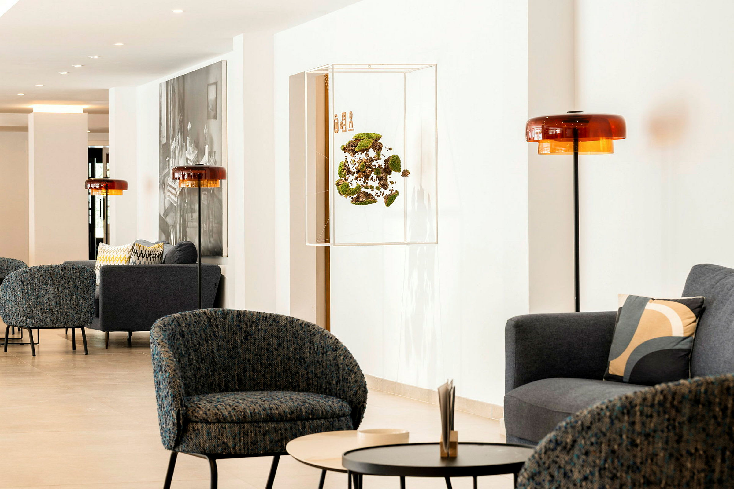 En moderne lounge med lænestole, sofaer og borde i et lyst indendørsmiljø. (AI-genereret tekst)