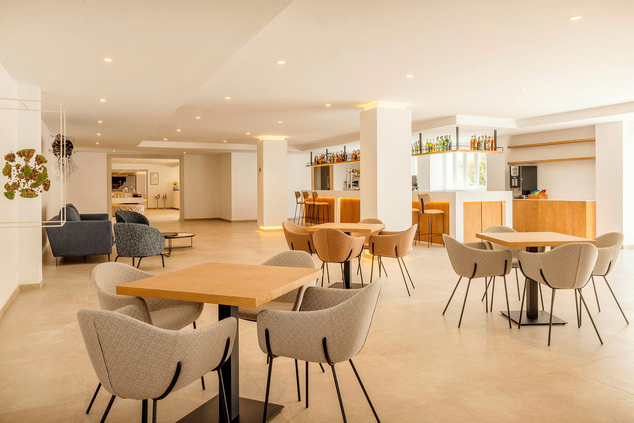 En moderne lounge med borde og stole samt en bar. (AI-genereret tekst)