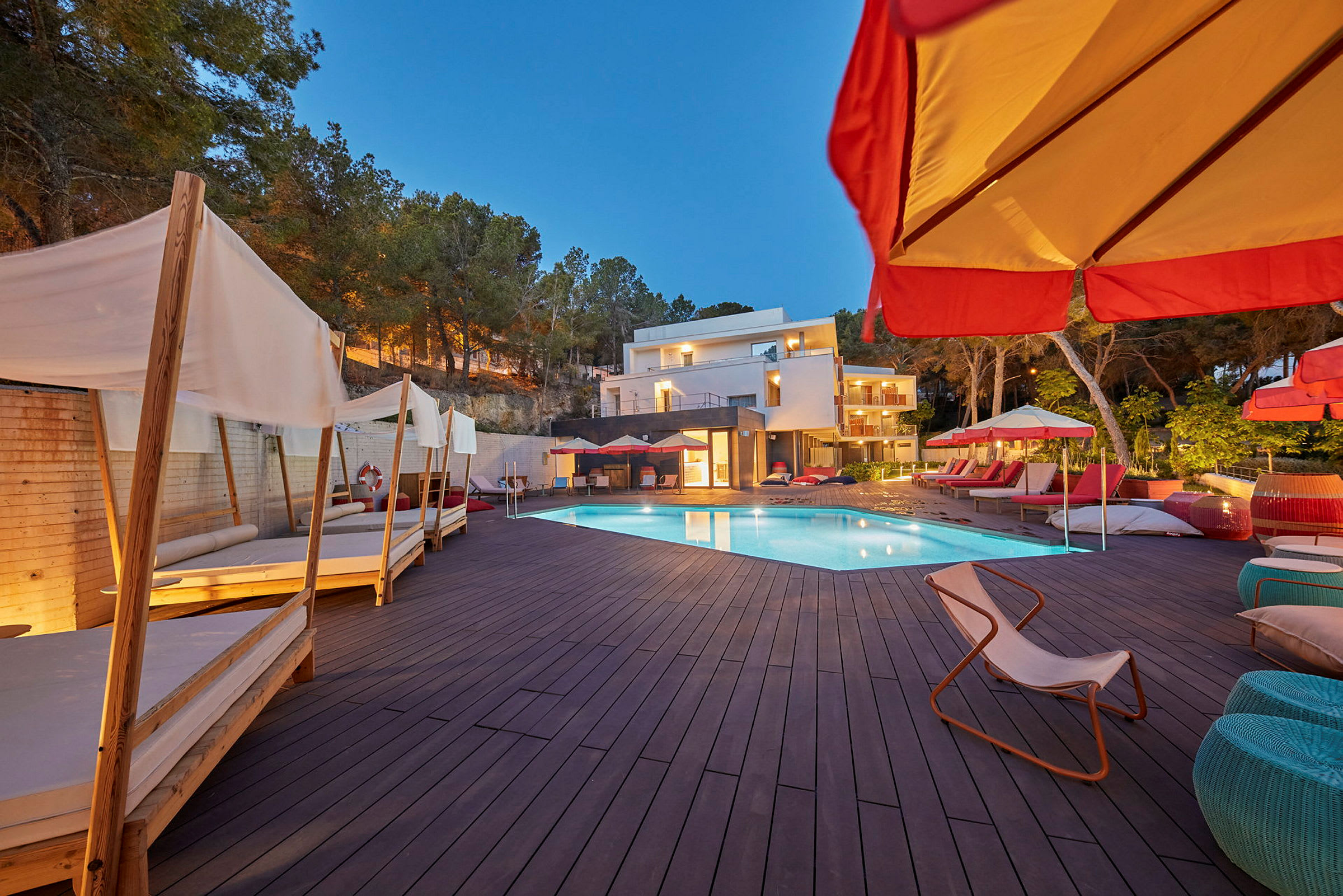 Udendørs pool med liggestole og parasoller ved et hotel. (AI-genereret tekst)