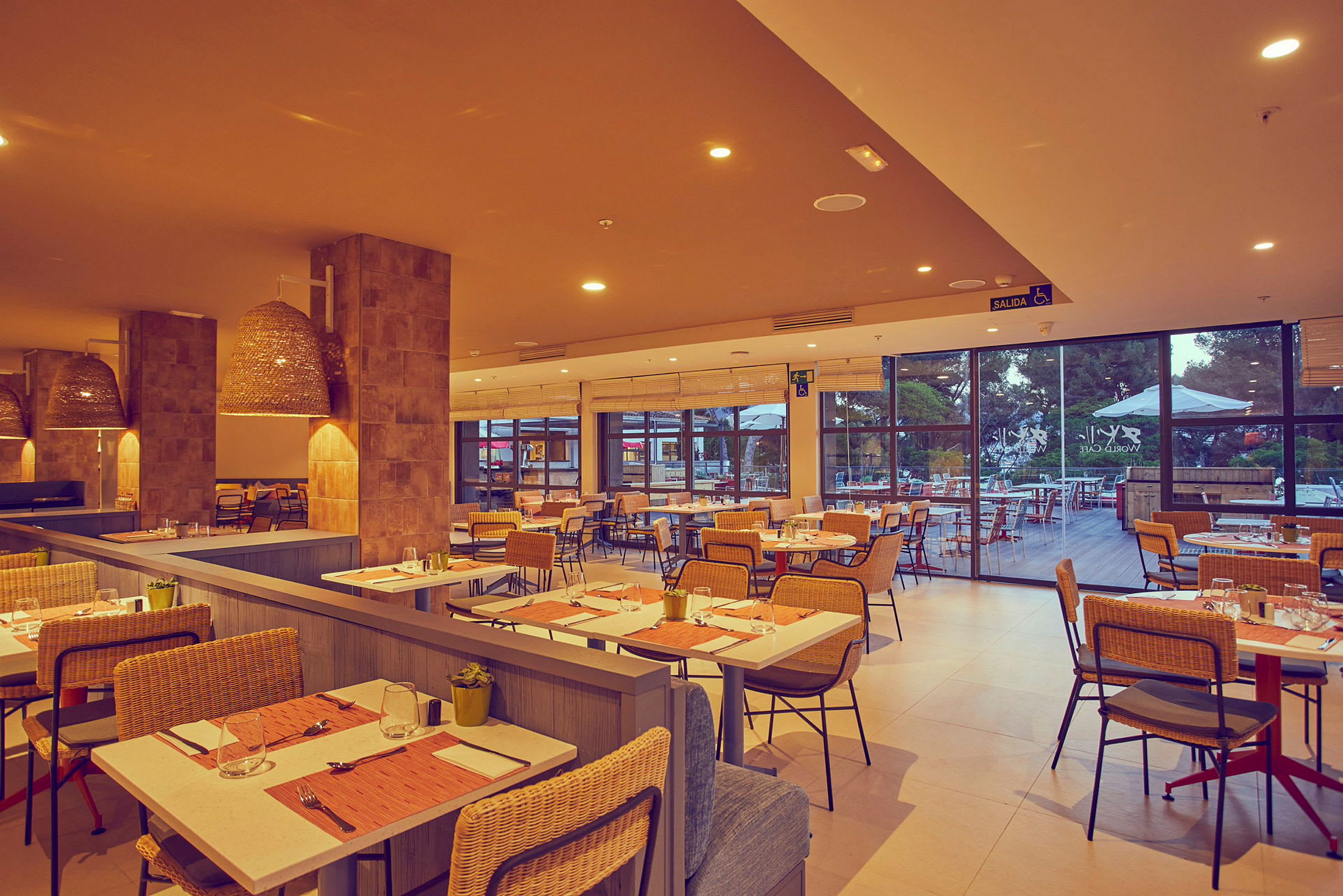 Interiør af en restaurant med dækkede borde og rottingstole. (AI-genereret tekst)