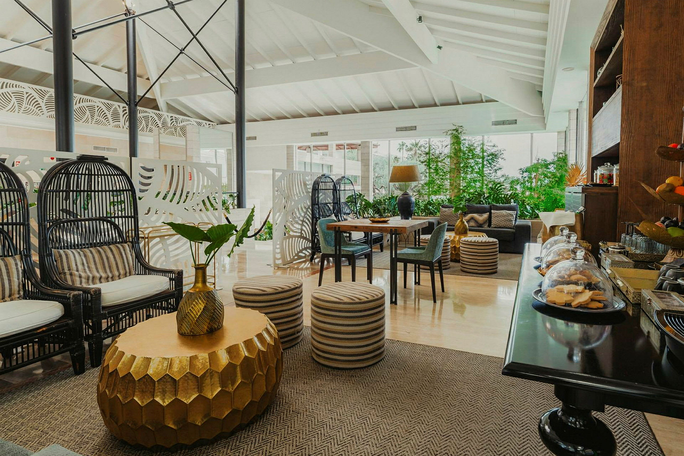Indretning af en lys og elegant lounge med siddepladser, borde og dekorative elementer. (AI-genereret tekst)