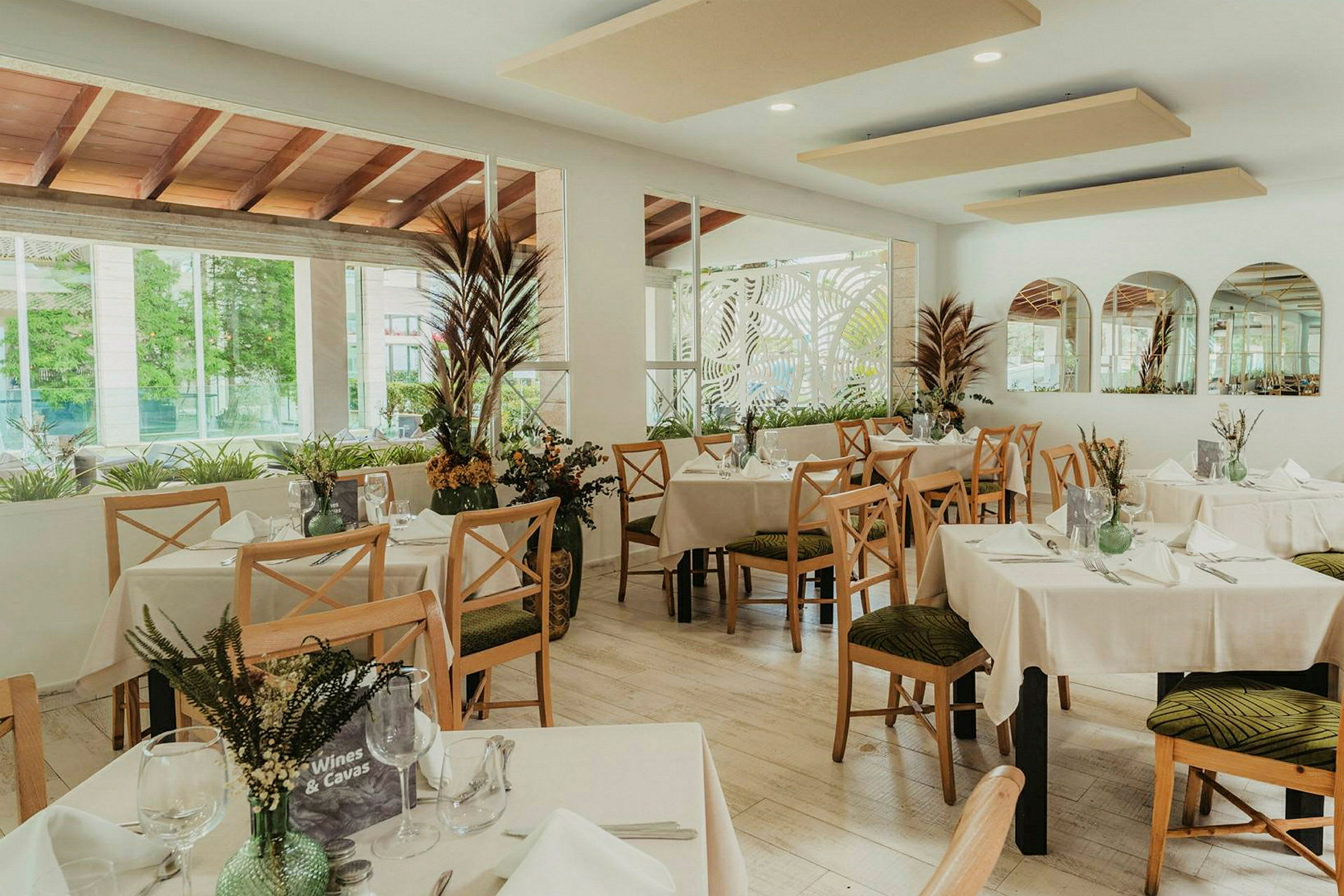 Moderne restaurant med dækkede borde og dekorative planteelementer. (AI-genereret tekst)