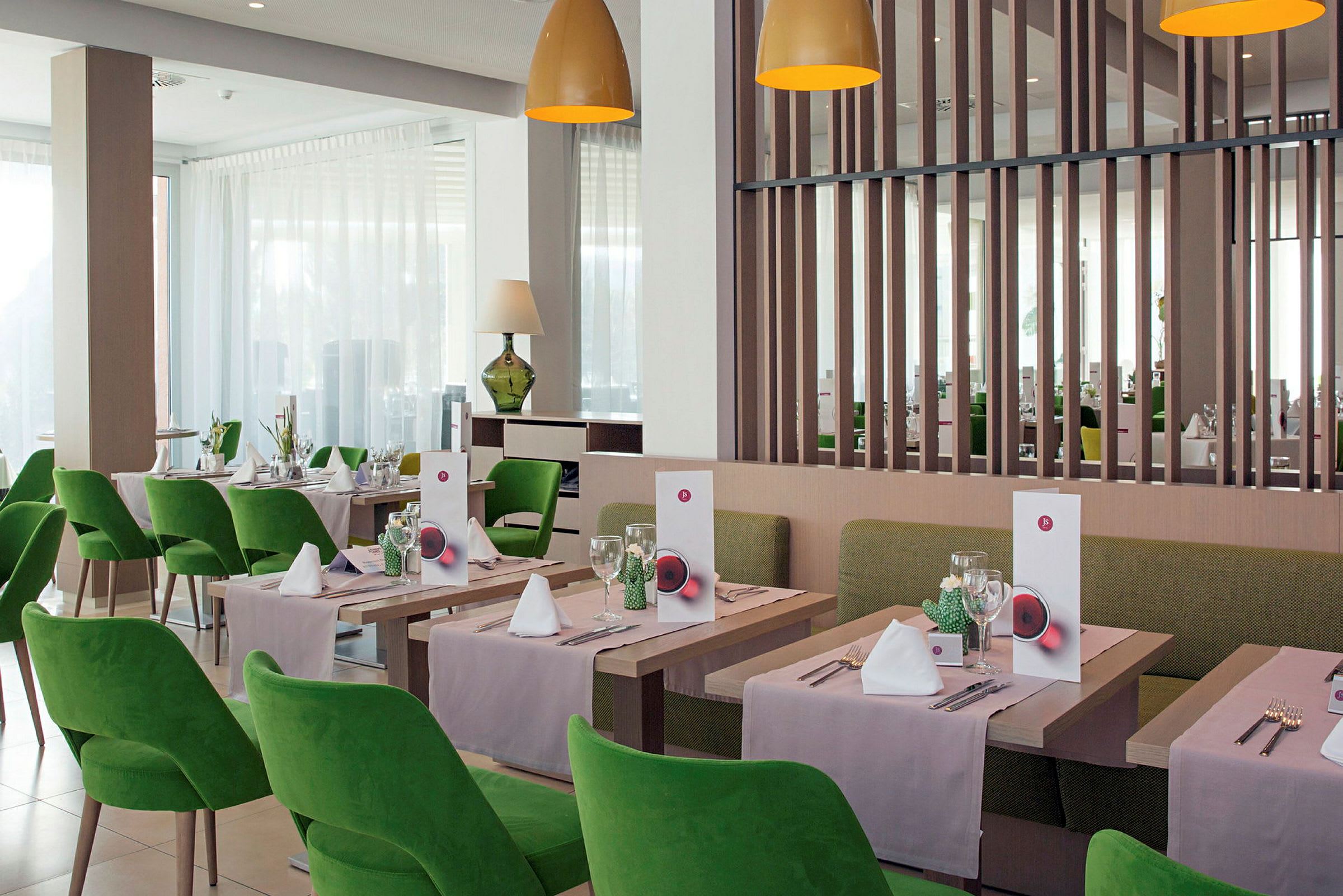Restaurant med grønne stole og opdækkede borde. (AI-genereret tekst)
