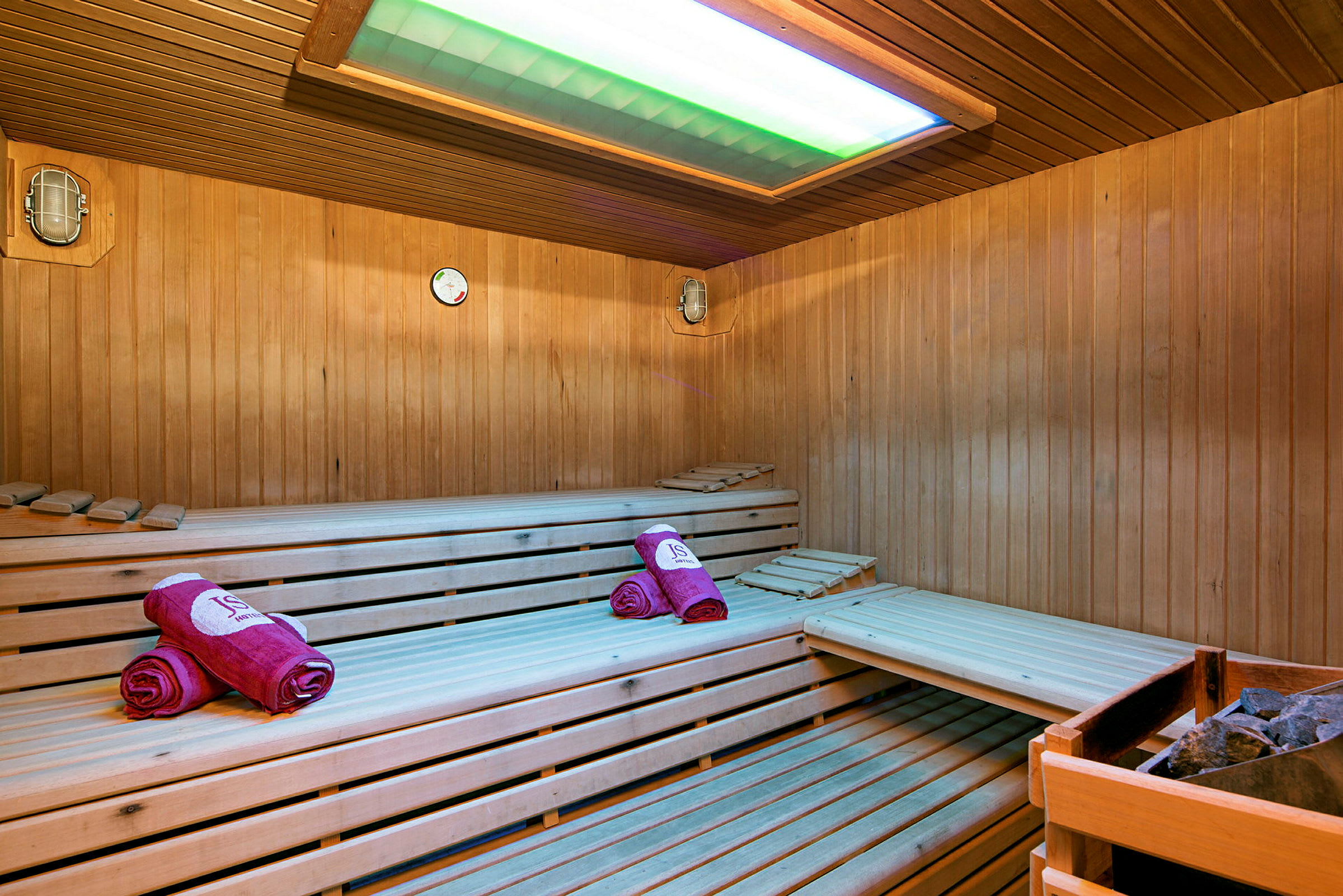 Billede af en sauna med trævægge og siddebænke samt håndklæder på bænken. (AI-genereret tekst)