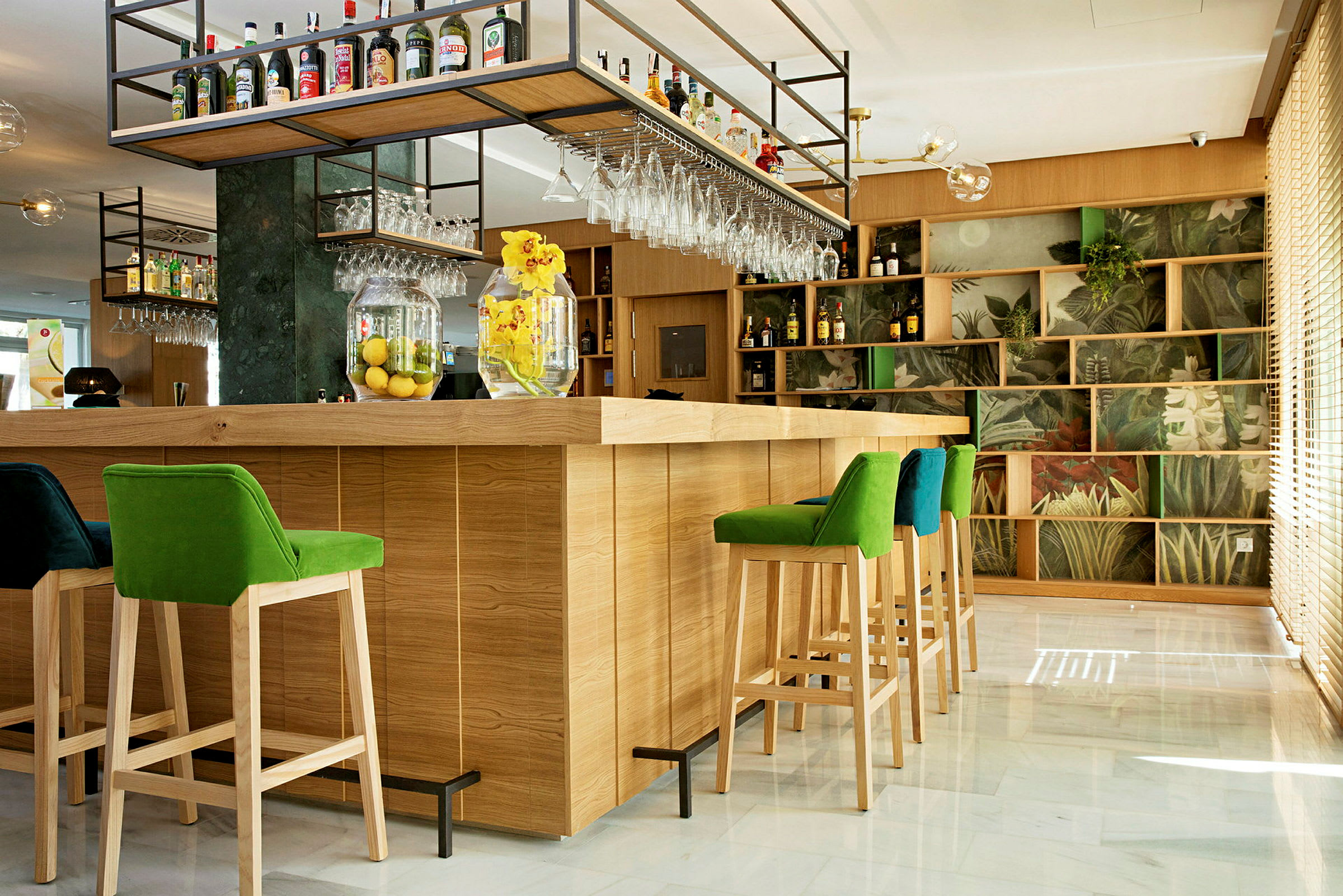 Moderne hotelbar med farverige høje stole, træpaneler og hylder dekoreret med plantemotiver. (AI-genereret tekst)