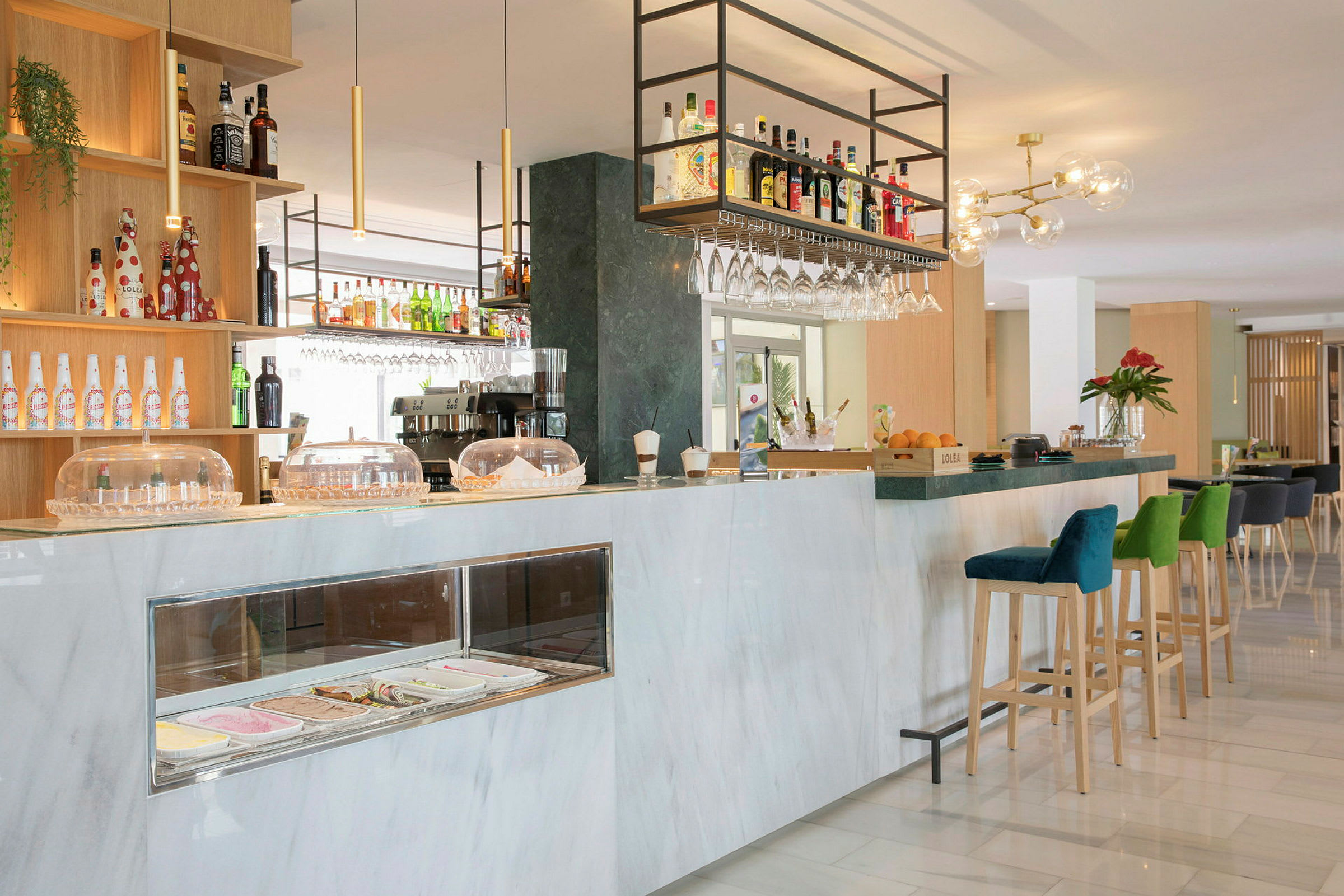 En moderne hotelbar med marmordisk, barstole og hylder fyldt med flasker. (AI-genereret tekst)