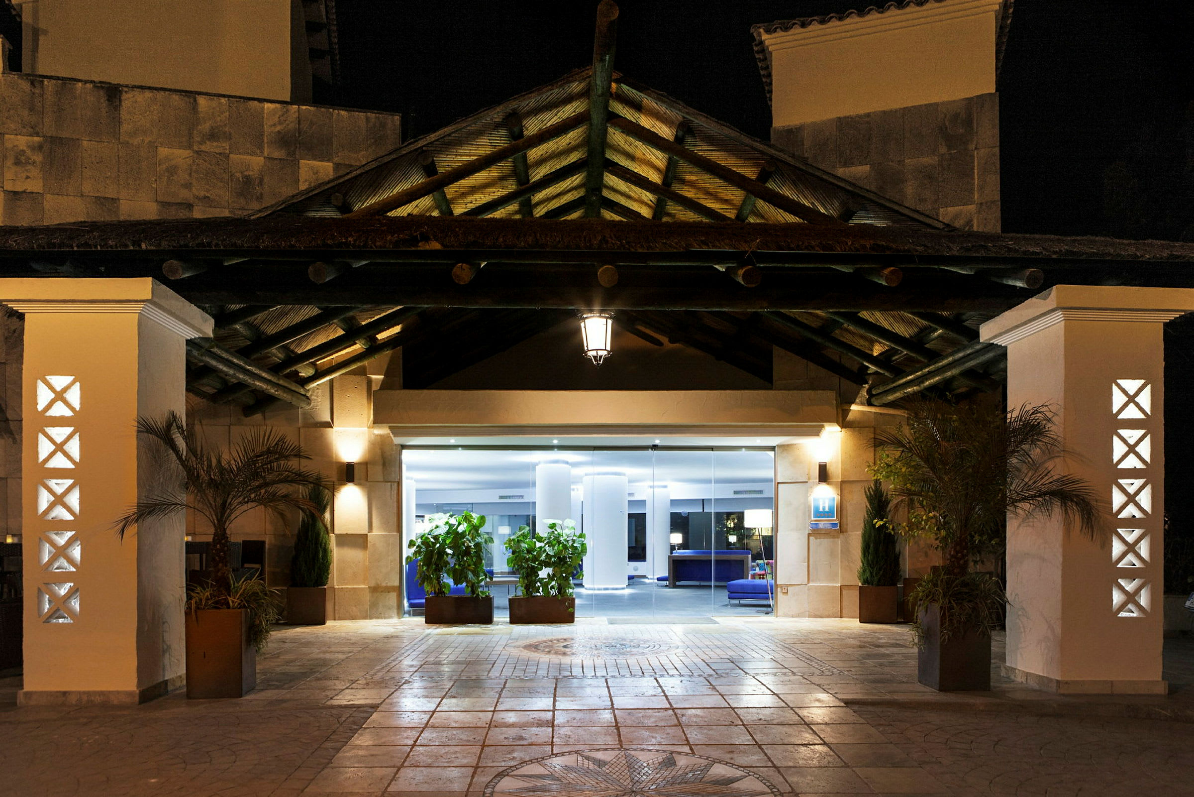 Hotelindgang oplyst om aftenen. (AI-genereret tekst)