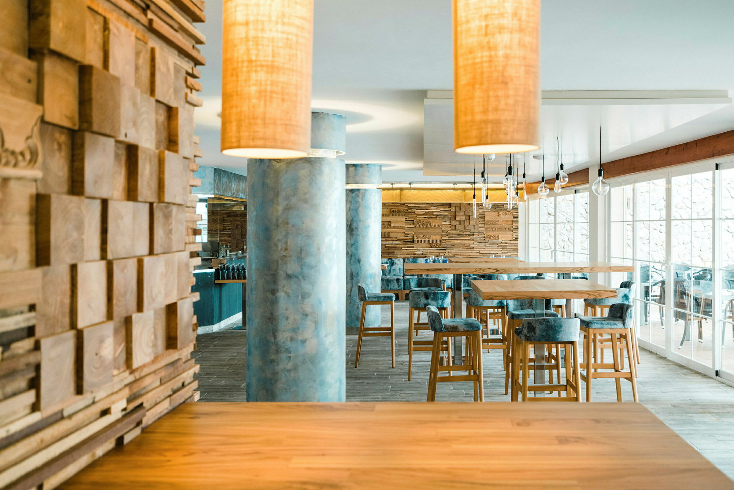 Moderne restaurantinteriør med træ og marmor samt høje borde og stole. (AI-genereret tekst)