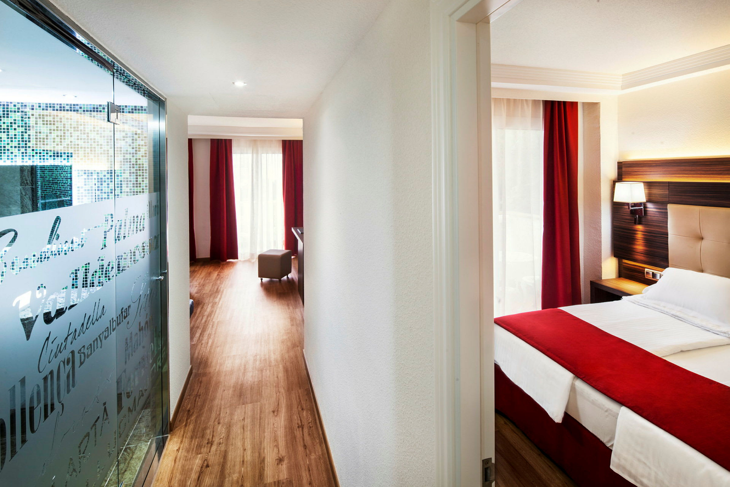 Hotelværelse med en seng og røde gardiner. (AI-genereret tekst)
