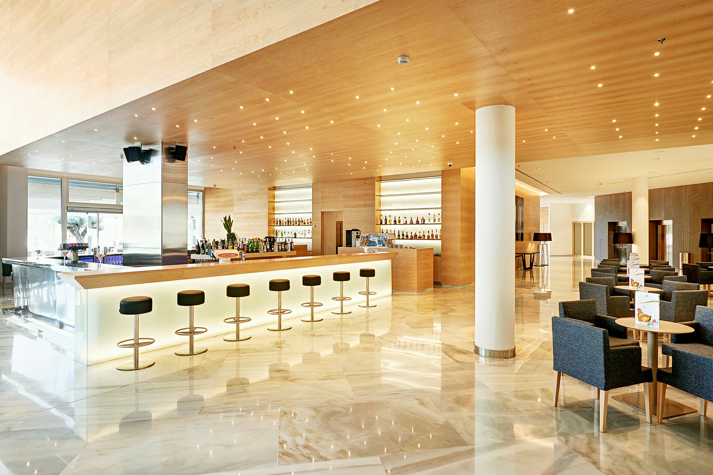 En elegant hotelbar med siddepladser og moderne indretning. (AI-genereret tekst)