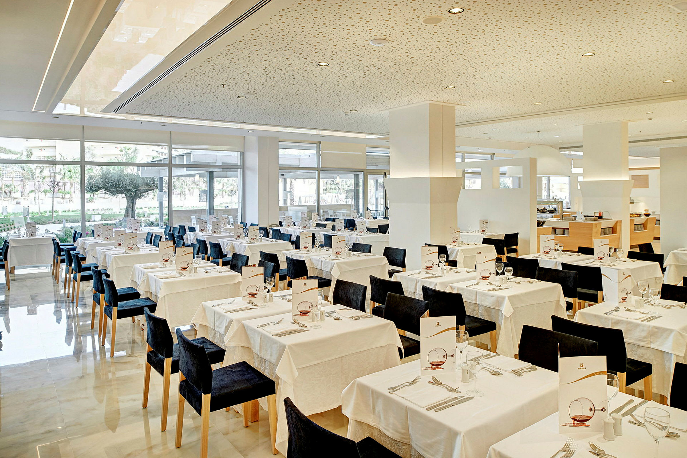 En lys restaurant med opstillede borde og stole, klar til gæster. (AI-genereret tekst)
