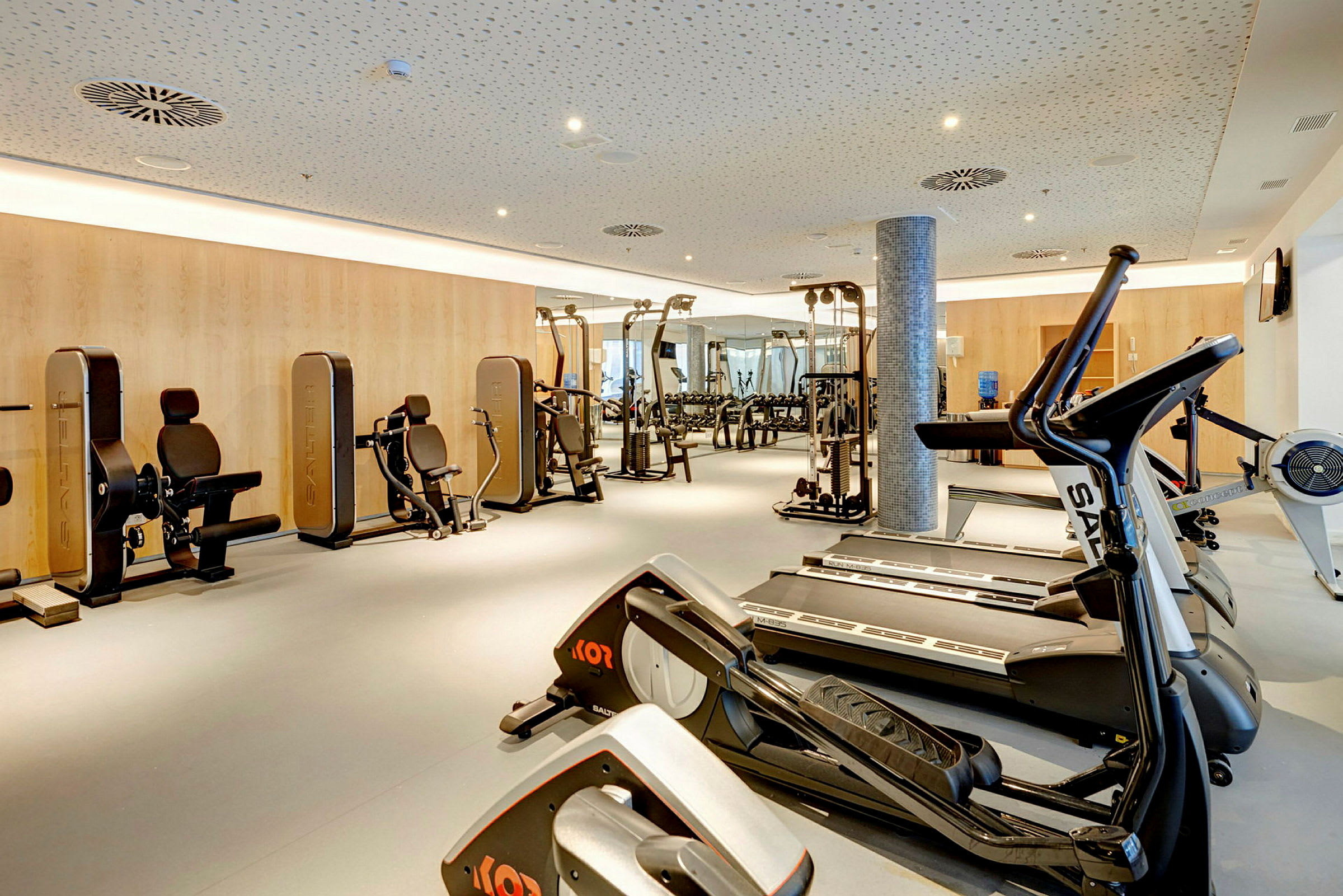 Et fitnesscenter med træningsmaskiner og løbebånd. (AI-genereret tekst)