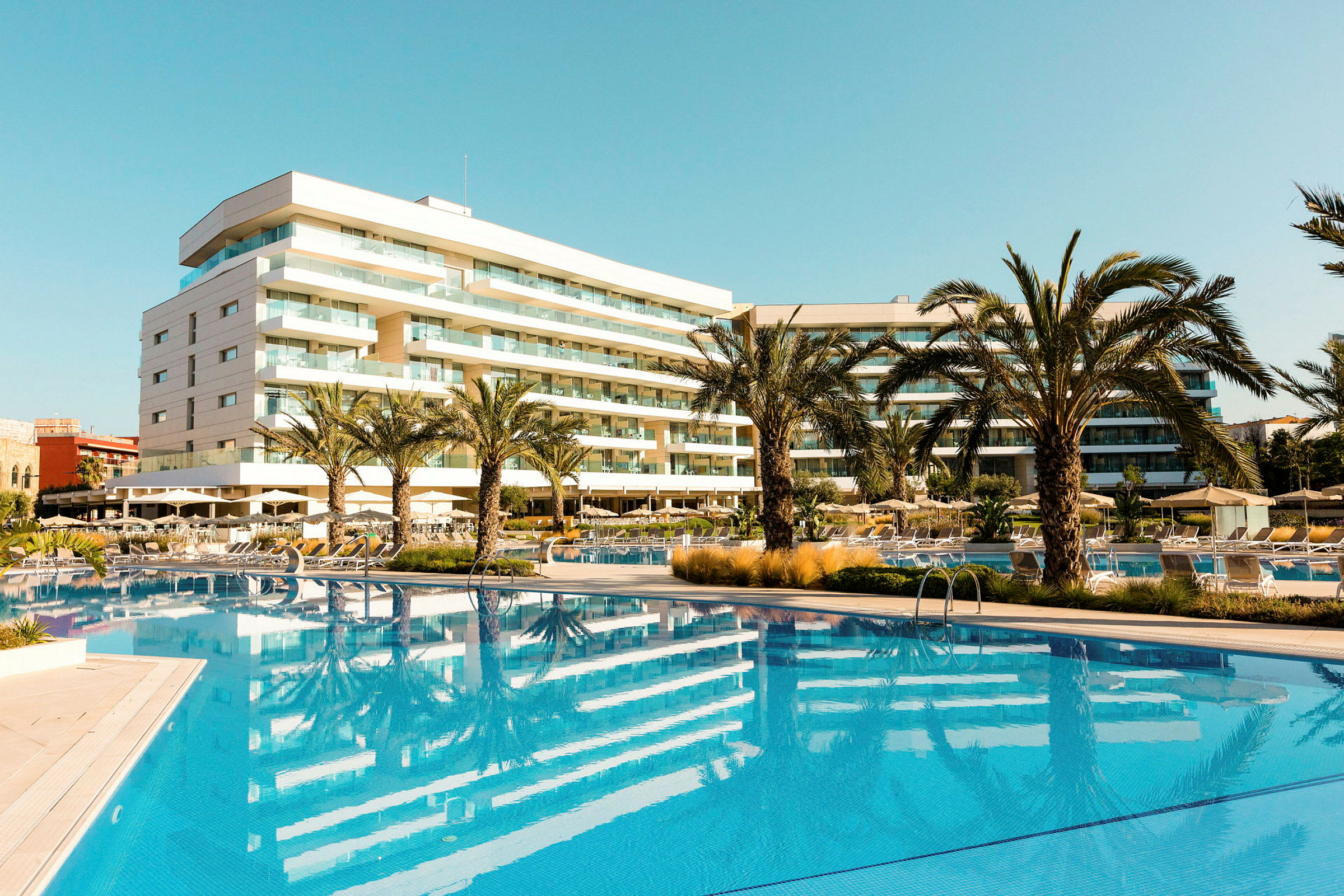 Hotel med pool og palmer i et solrigt område. (AI-genereret tekst)