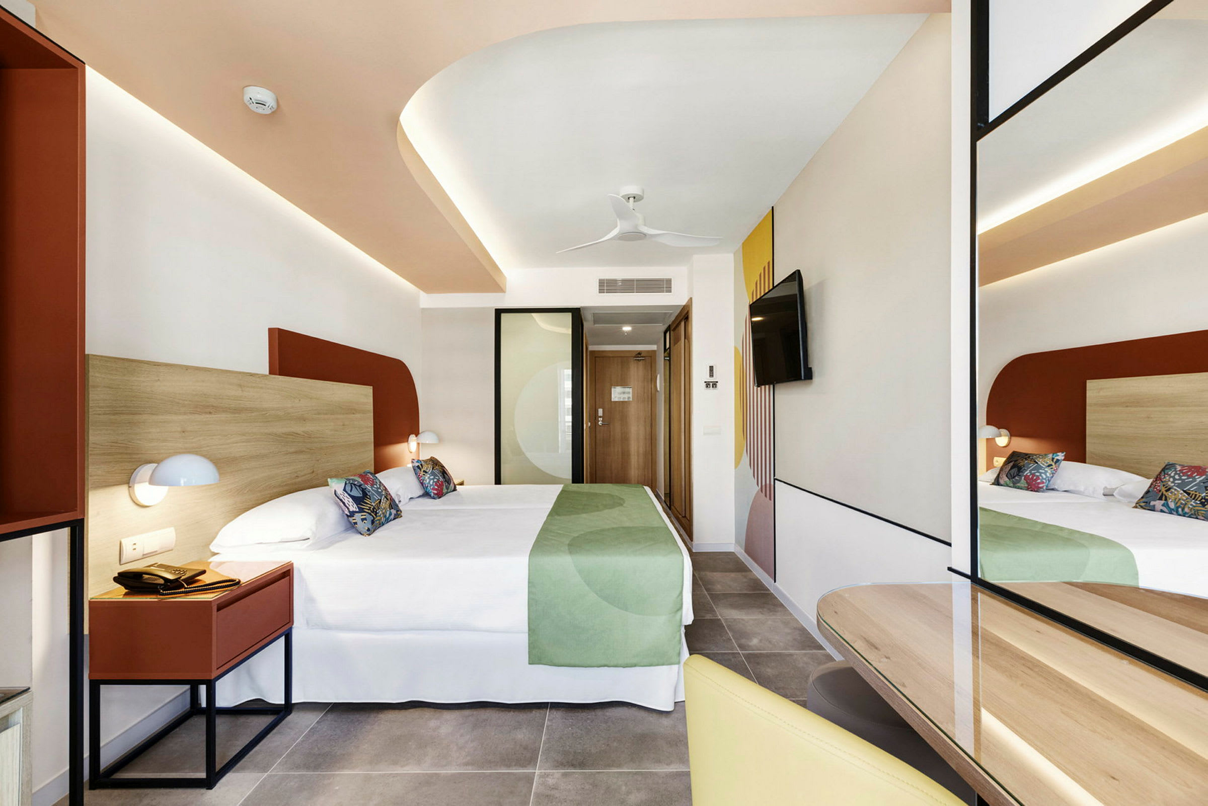 Hotelværelse med moderne indretning, dobbeltseng og spejl. (AI-genereret tekst)