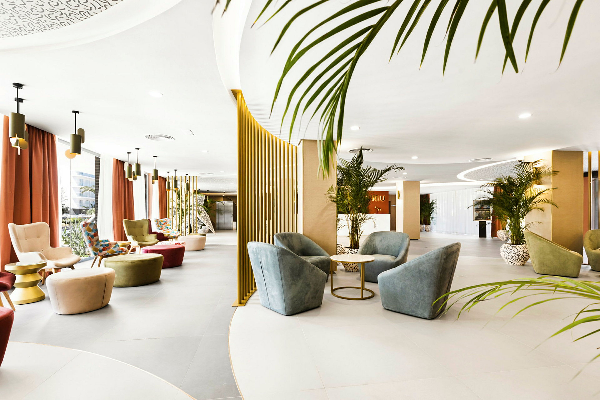 En åben hotellobby med moderne møbler, planter og designlamper. (AI-genereret tekst)