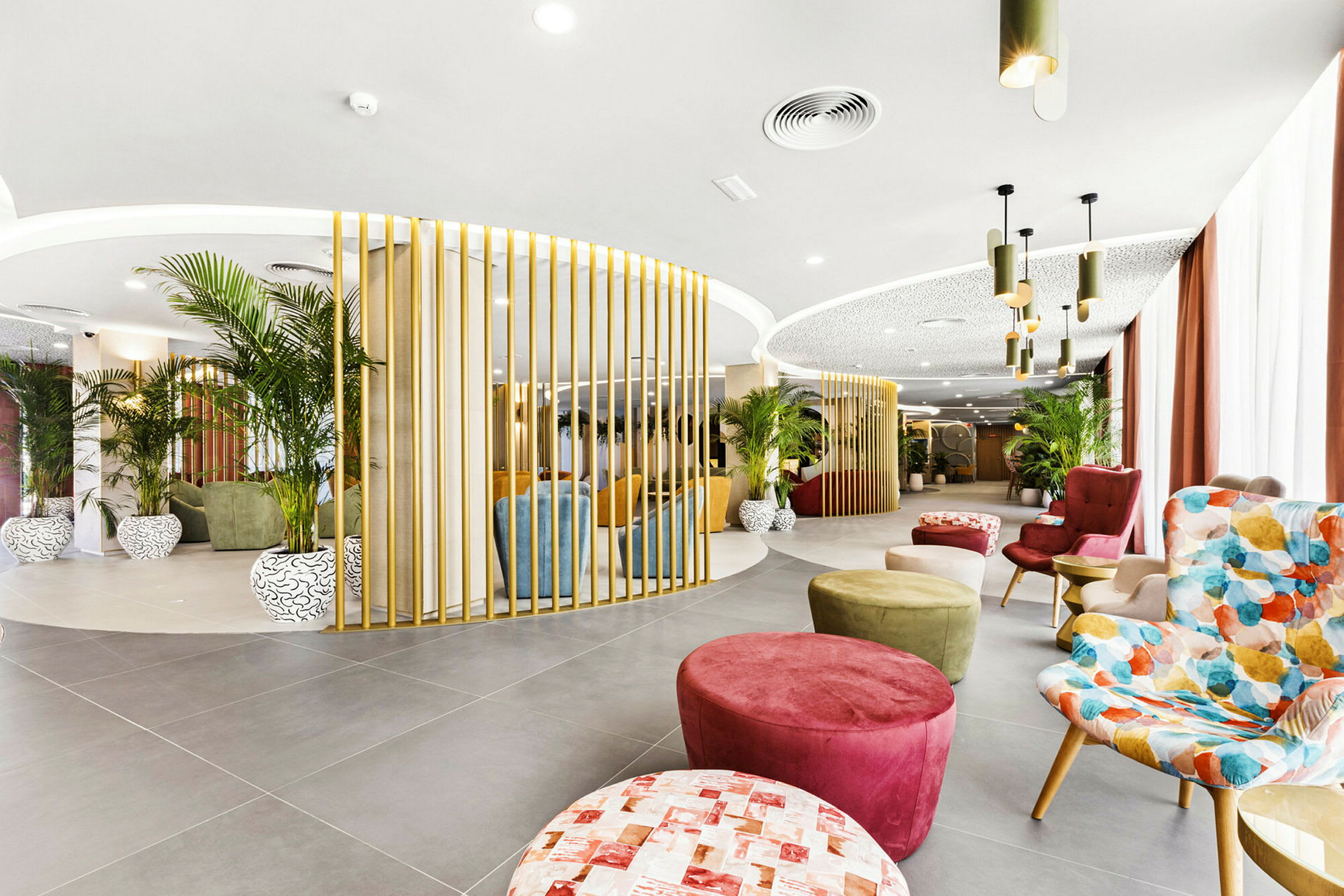En moderne lounge med farverige siddepladser, planteudsmykning og elegant belysning. (AI-genereret tekst)