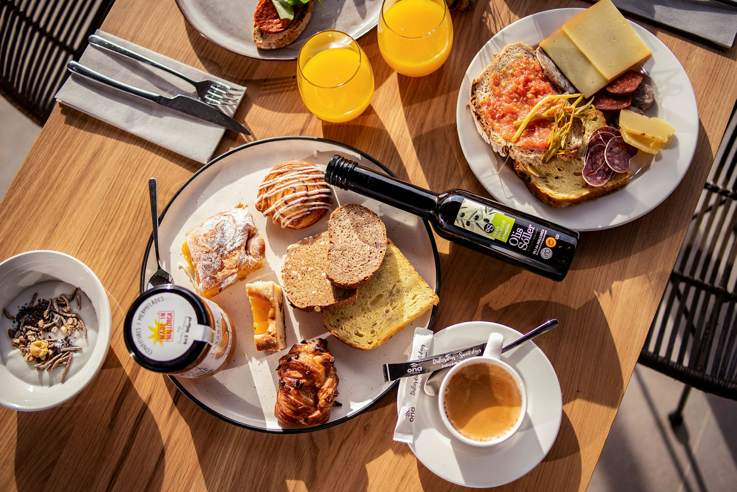 Et bord dækket med en morgenmad, der inkluderer brød, bagværk, juice, kaffe og pålæg. (AI-genereret tekst)