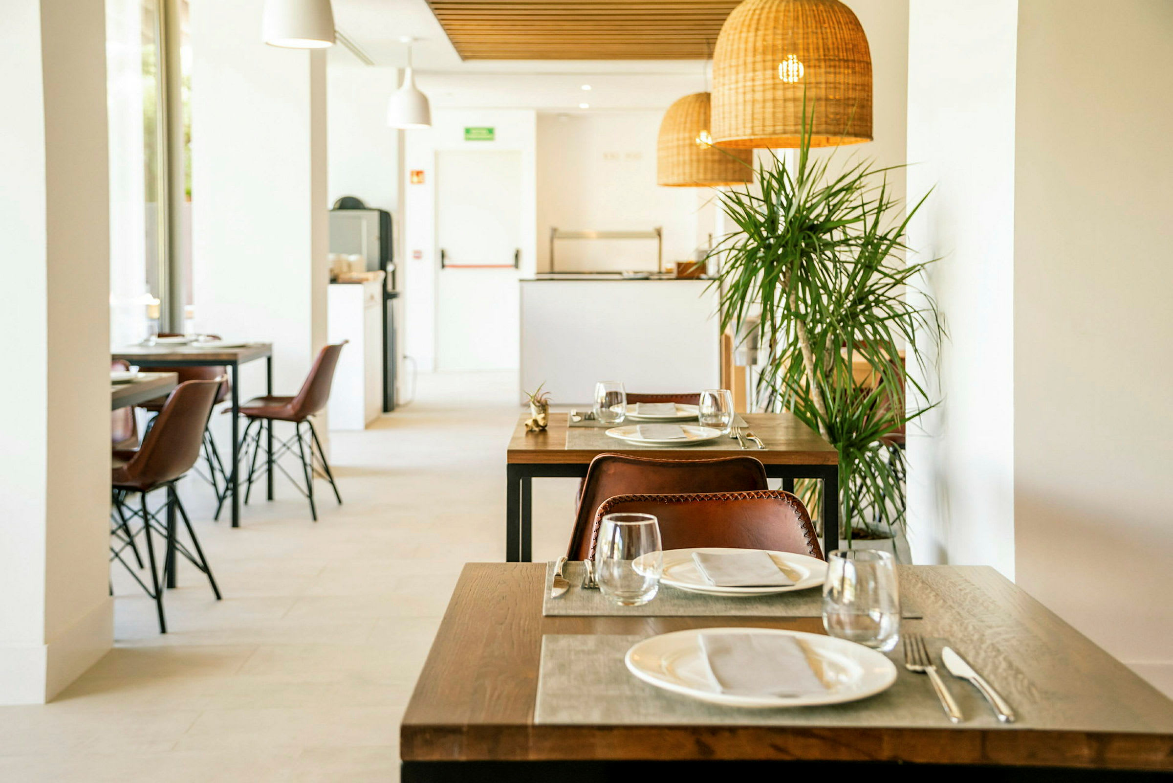Restaurant med dækkede borde og stole. (AI-genereret tekst)