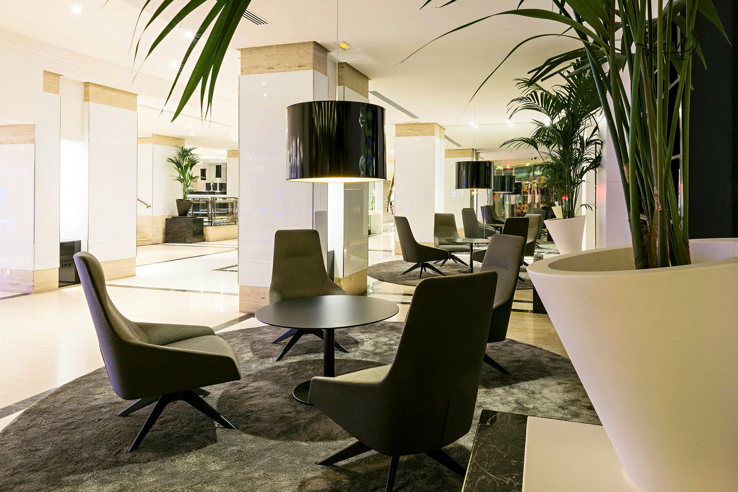 Interiør af et moderne loungeområde med siddegrupper og dekorative planter. (AI-genereret tekst)