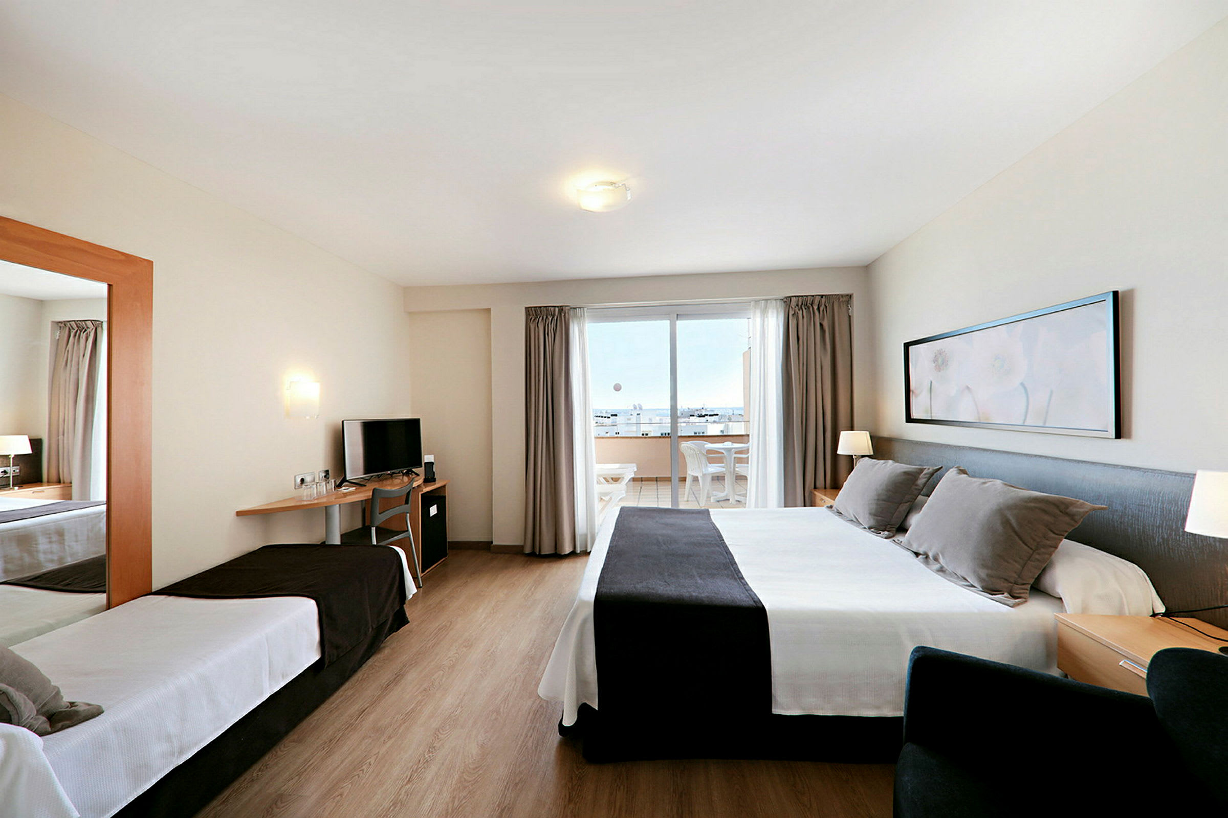 Et hotelværelse med to senge, et fjernsyn og en balkon med udsigt. (AI-genereret tekst)