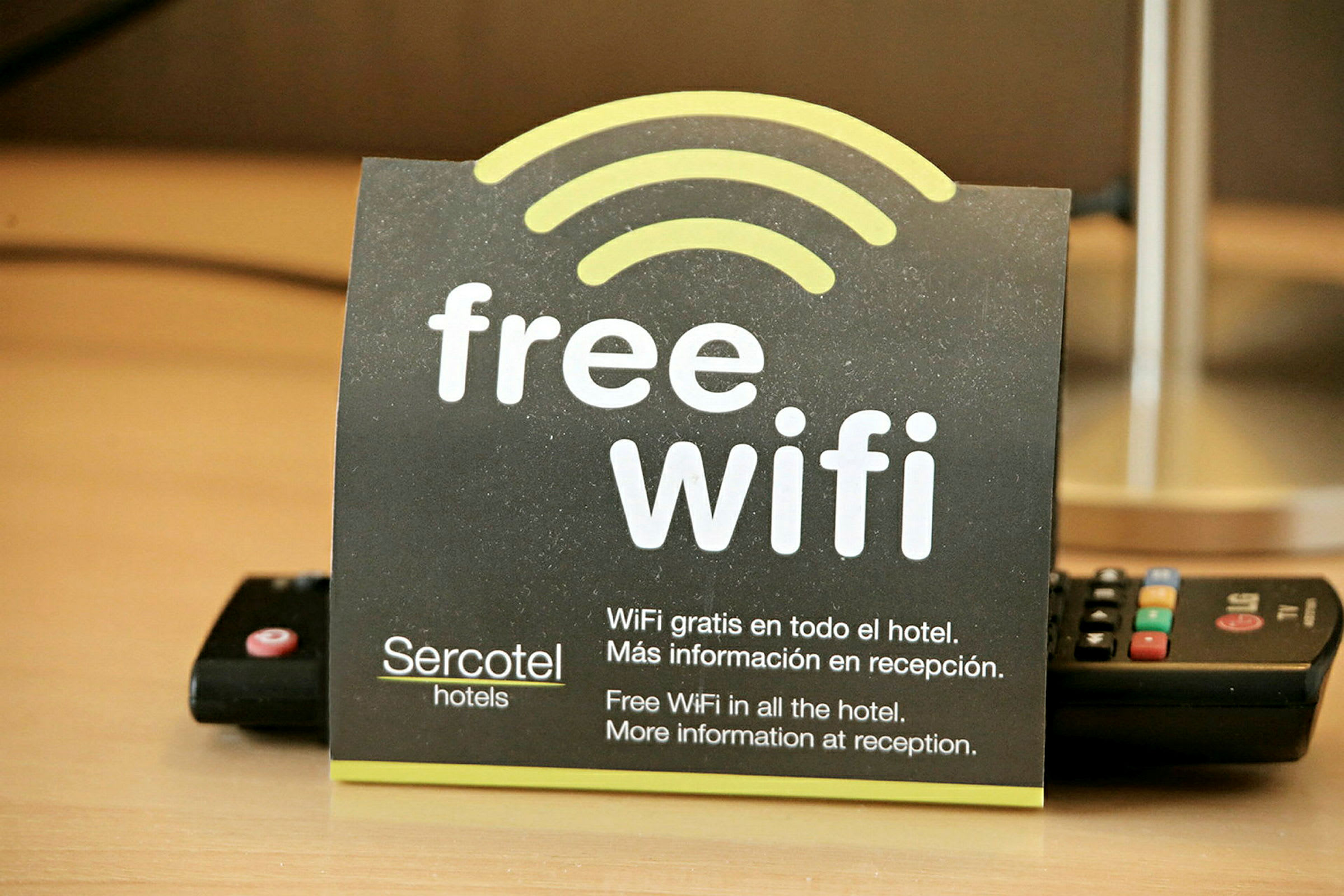 Et kort der informerer om gratis Wi-Fi på et hotel, med tekst på både engelsk og spansk. (AI-genereret tekst)