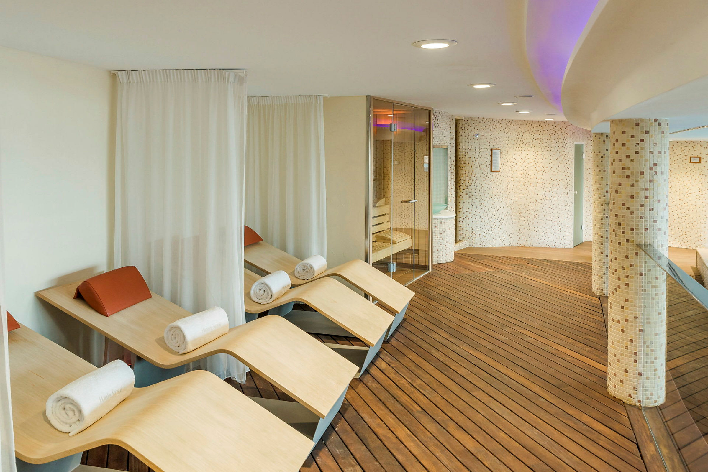 Moderne spa-afslapningsområde med træbænke og håndklæder. (AI-genereret tekst)