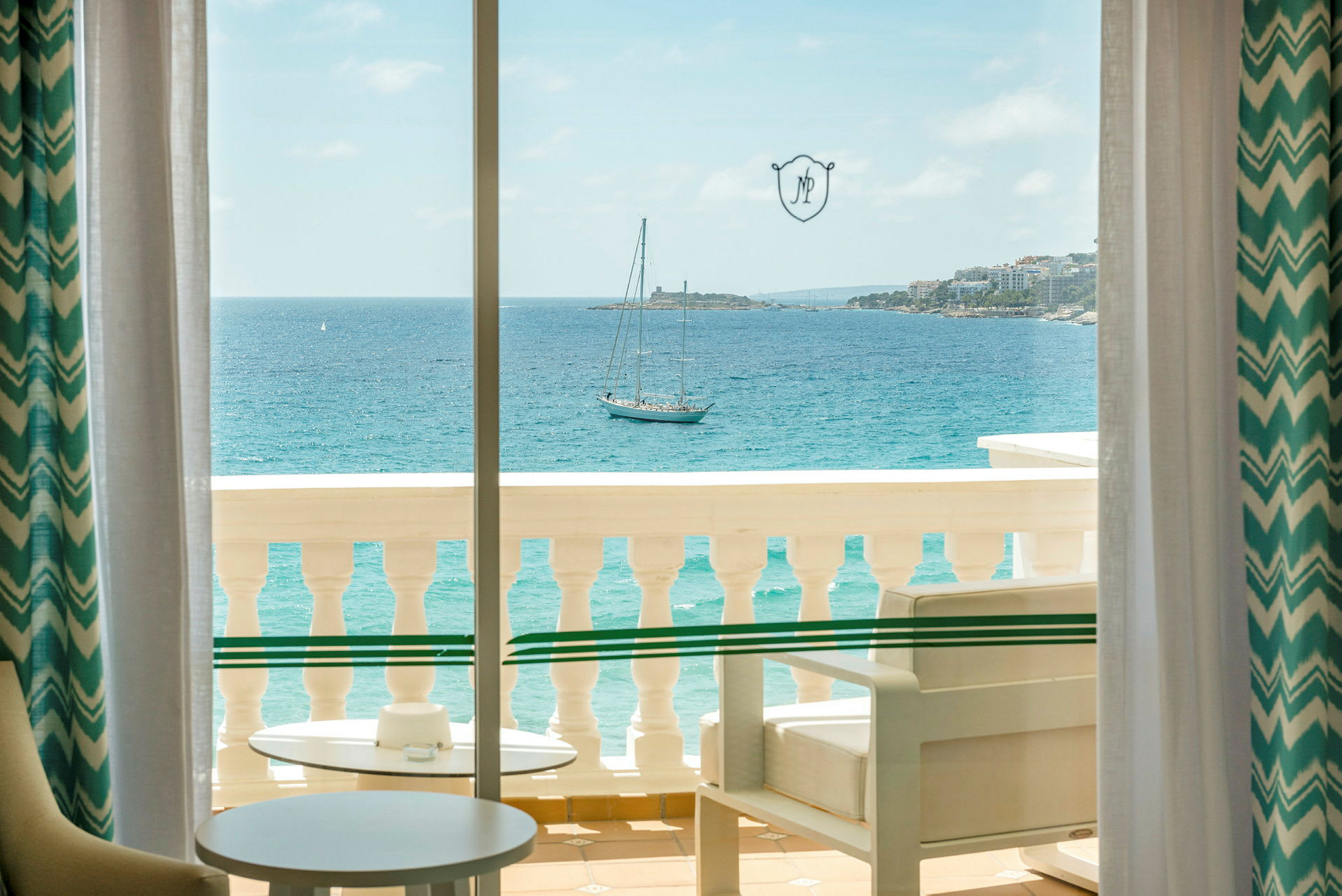 Udsigt over havet fra en balkon med møbler. (AI-genereret tekst)