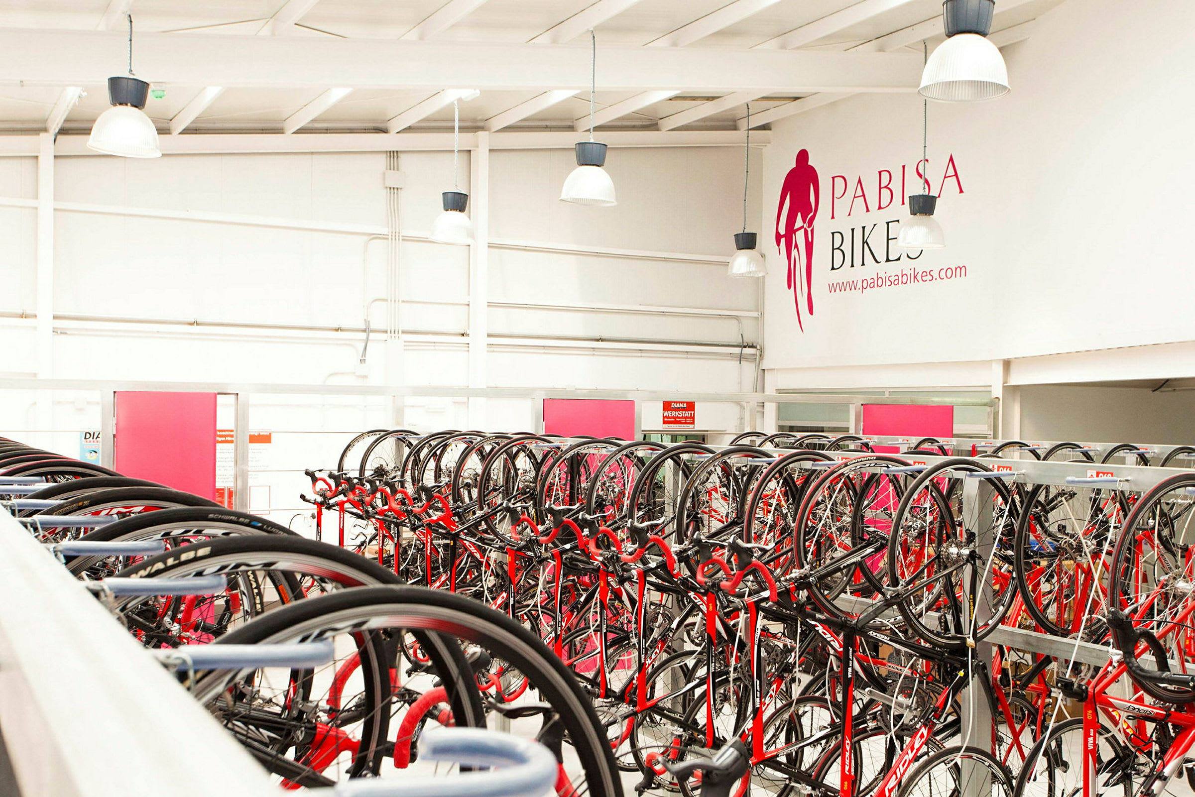 Cykler arrangeret på stativer i en butik. (AI-genereret tekst)