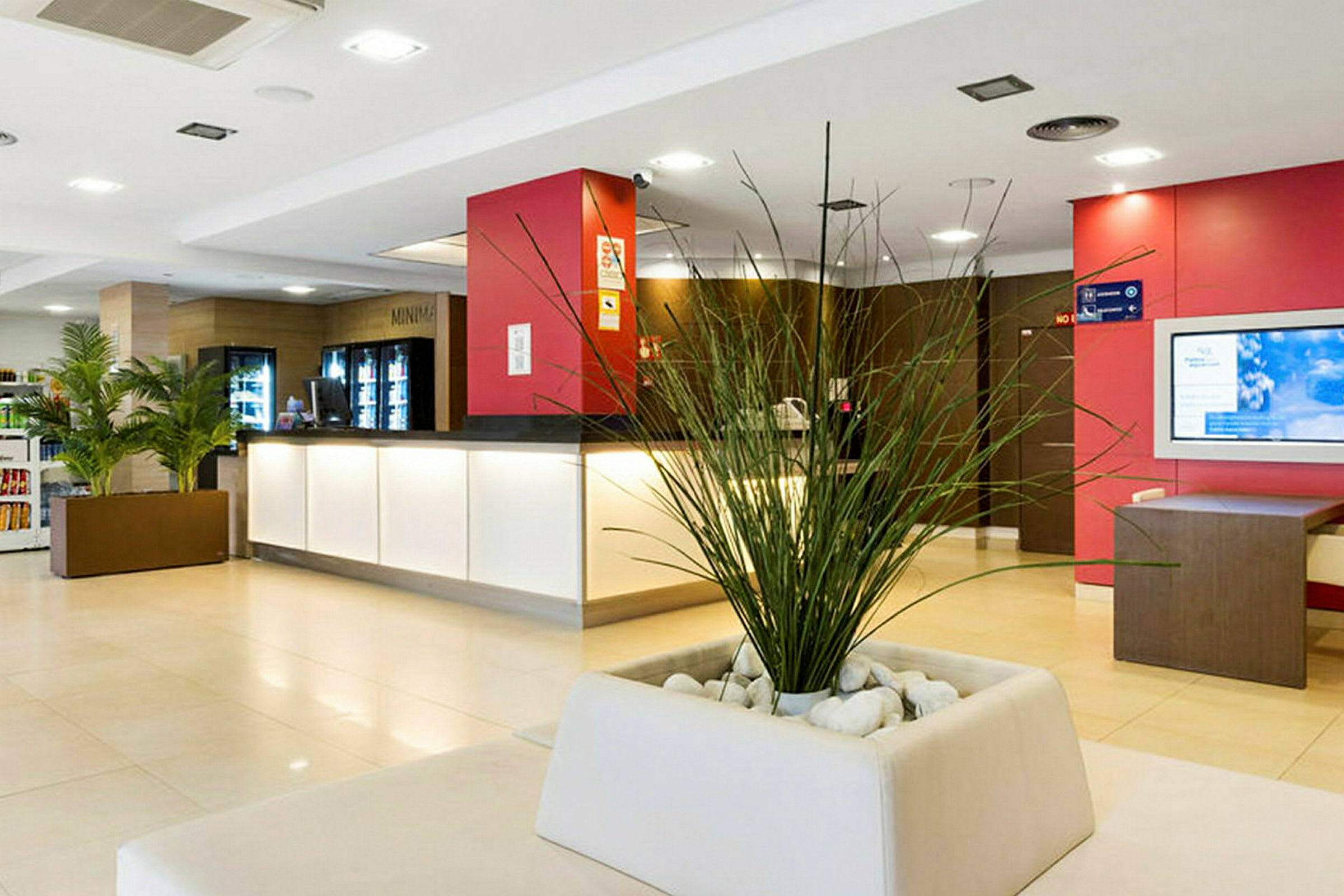 Hotelreception med en stor plante i midten. (AI-genereret tekst)