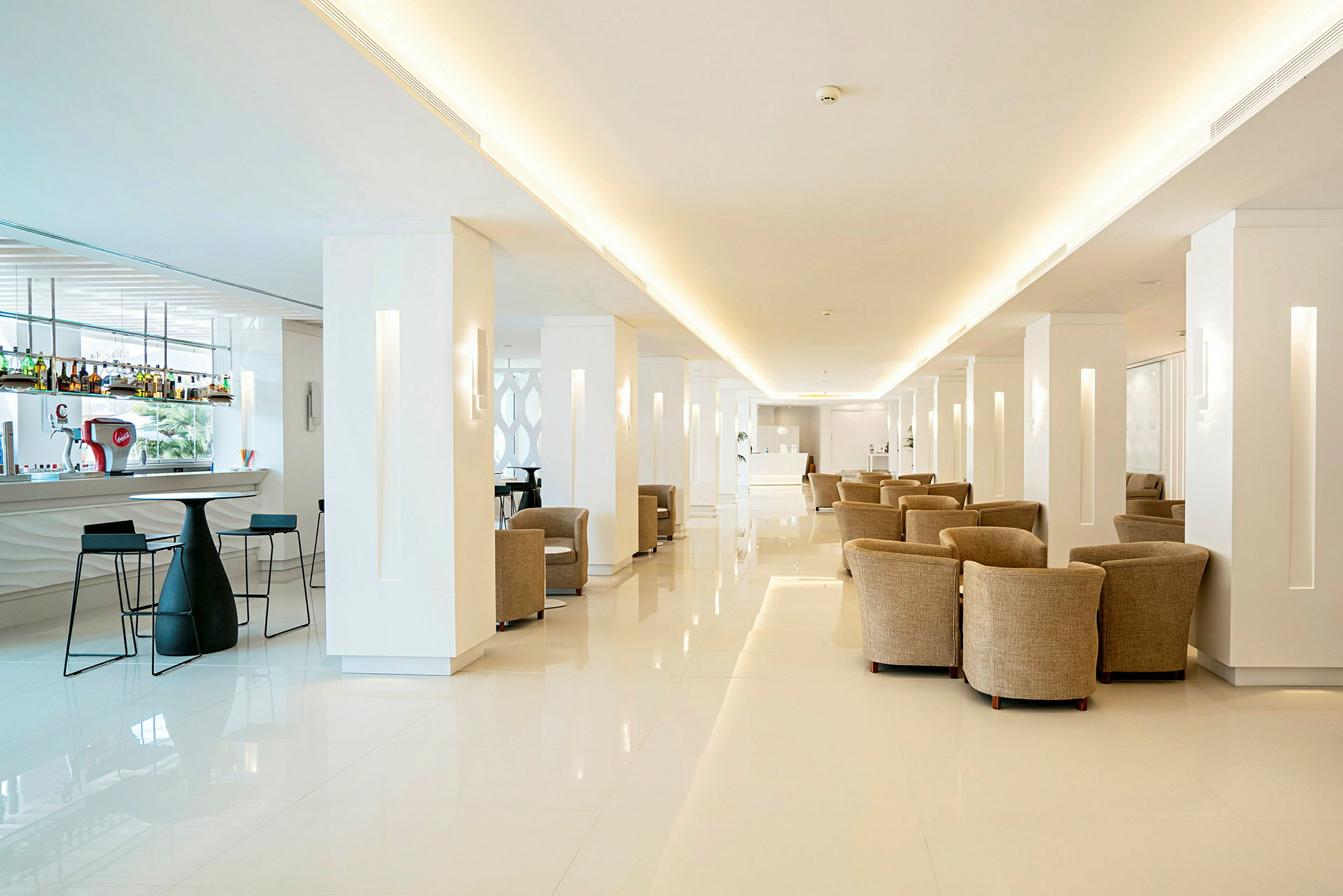 Lys og moderne hotellets lobby med bar og siddeområder. (AI-genereret tekst)