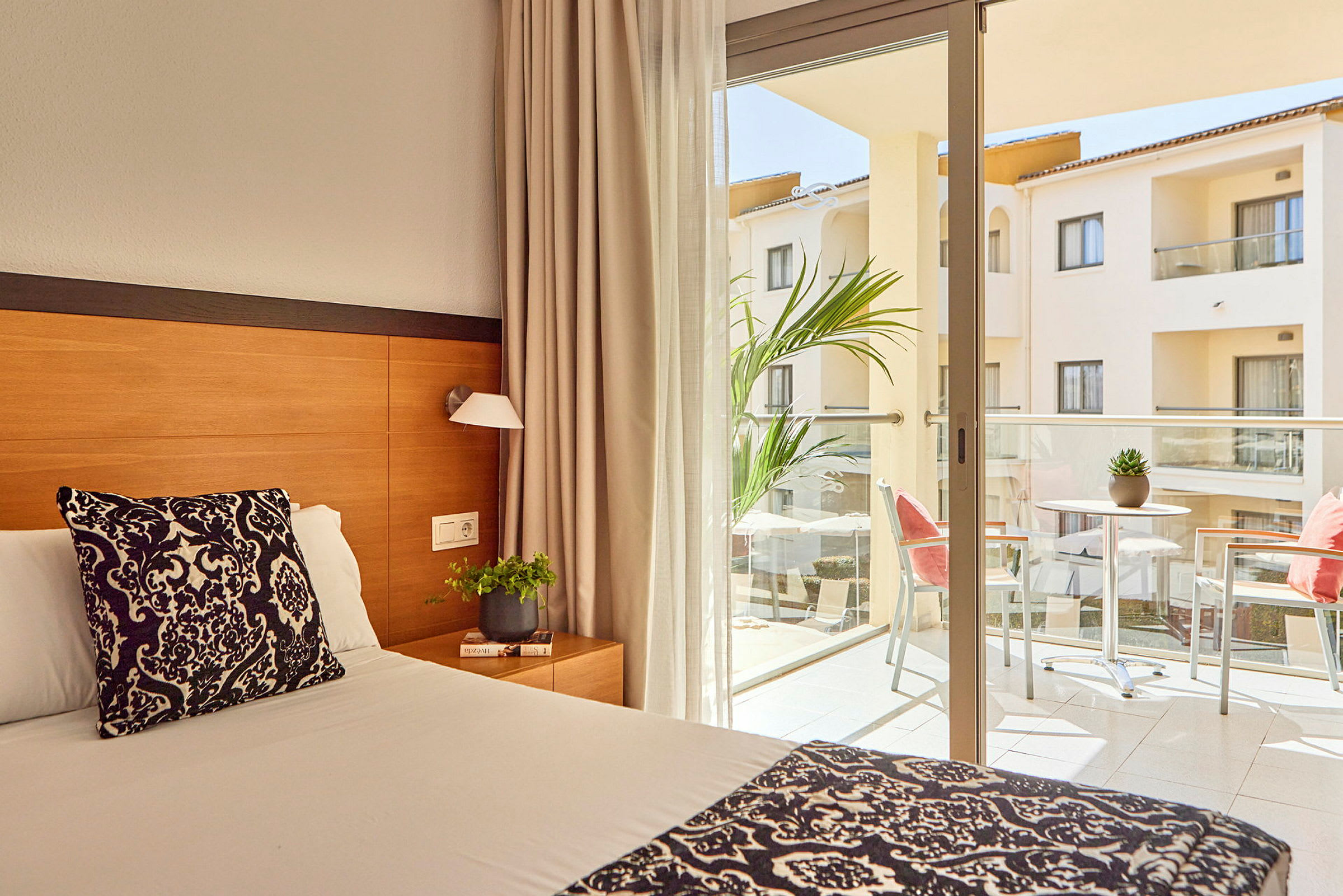 Hotelværelse med seng og balkon med møbler. (AI-genereret tekst)
