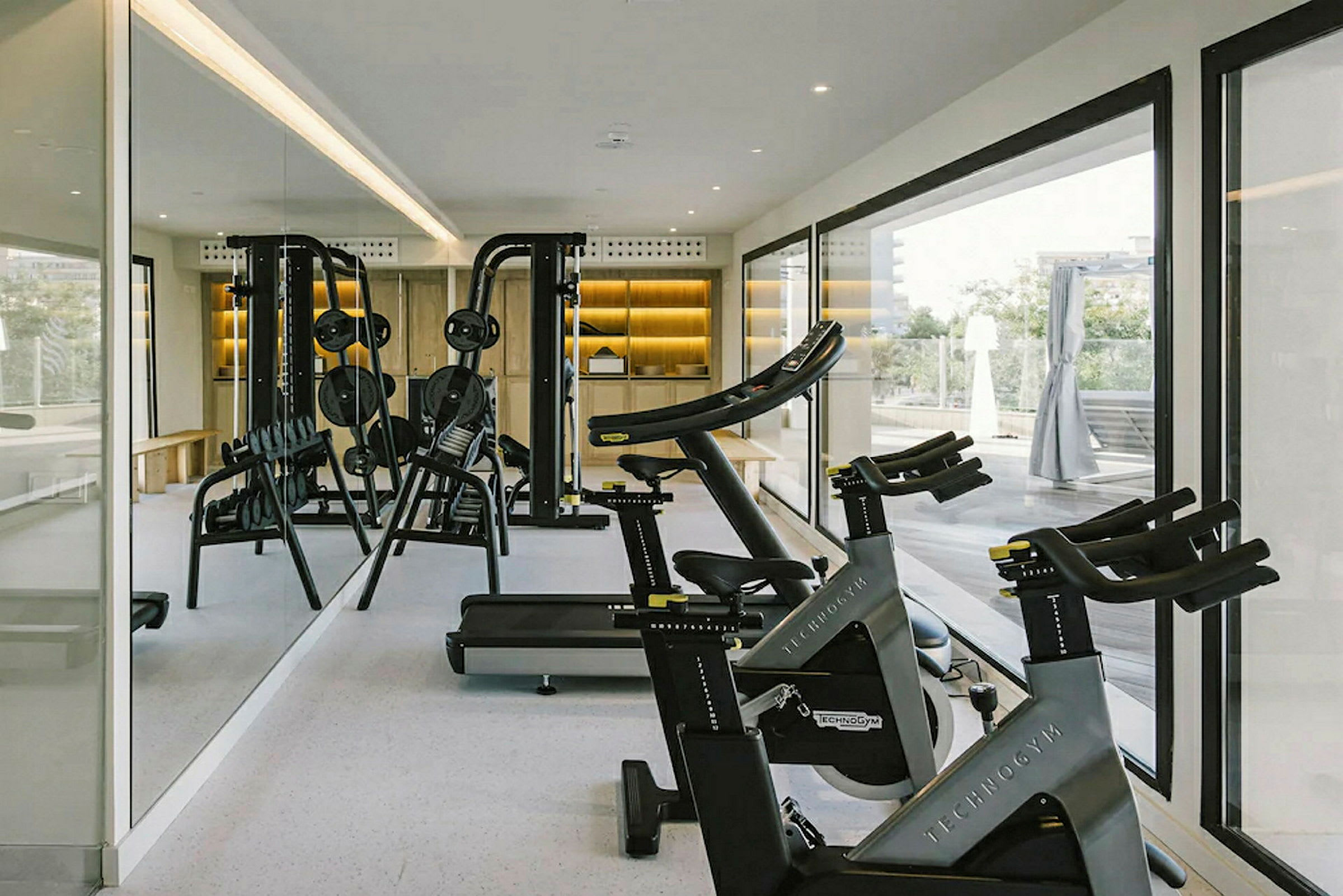 Et fitnessrum med træningsudstyr som motionscykler og vægtholder. (AI-genereret tekst)