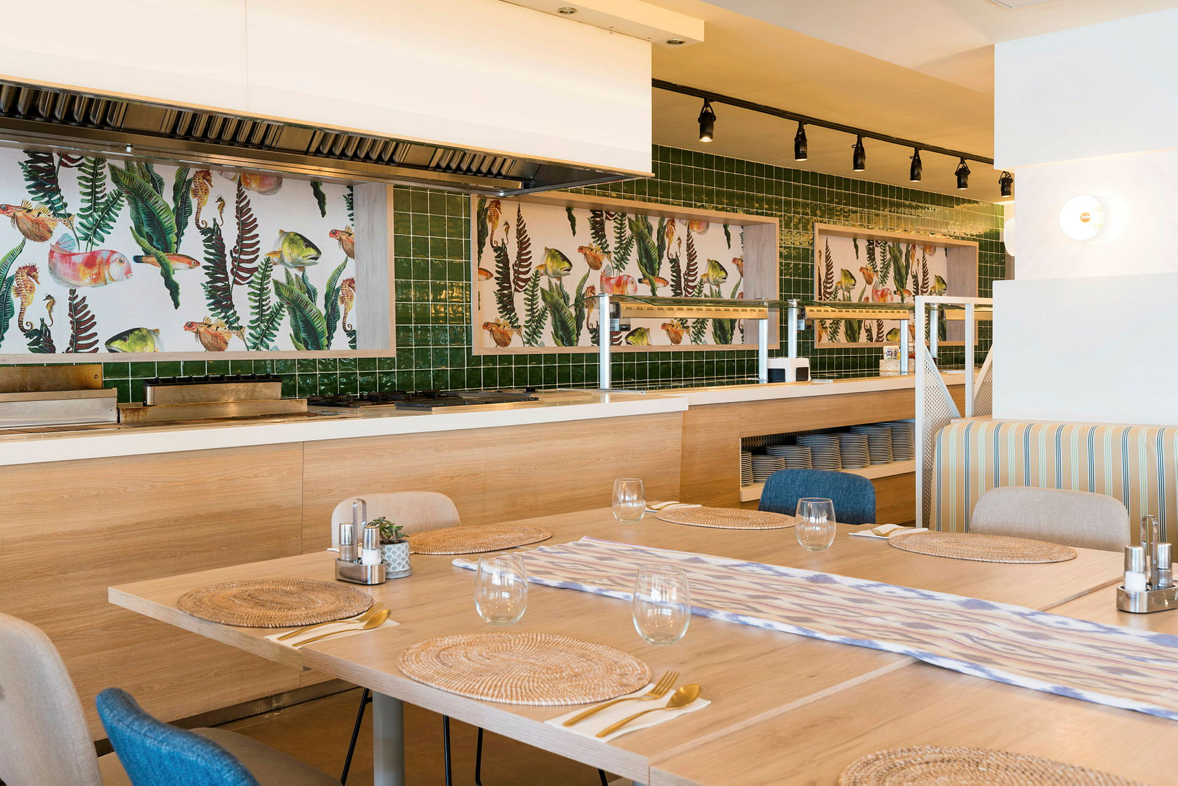 En restaurantinteriør med opstillede borde og kunstværker på væggen bagved. (AI-genereret tekst)