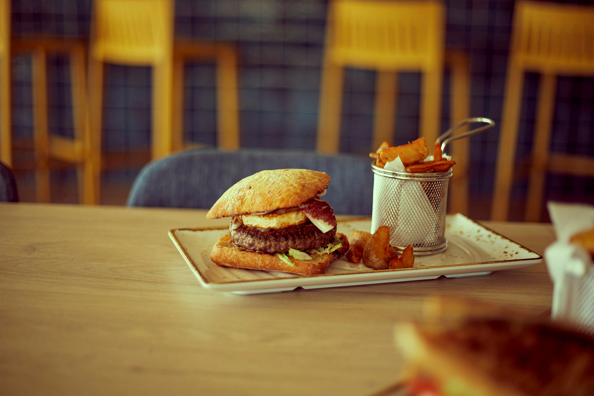 En tallerken med burger og medfølgende pommes frites. (AI-genereret tekst)