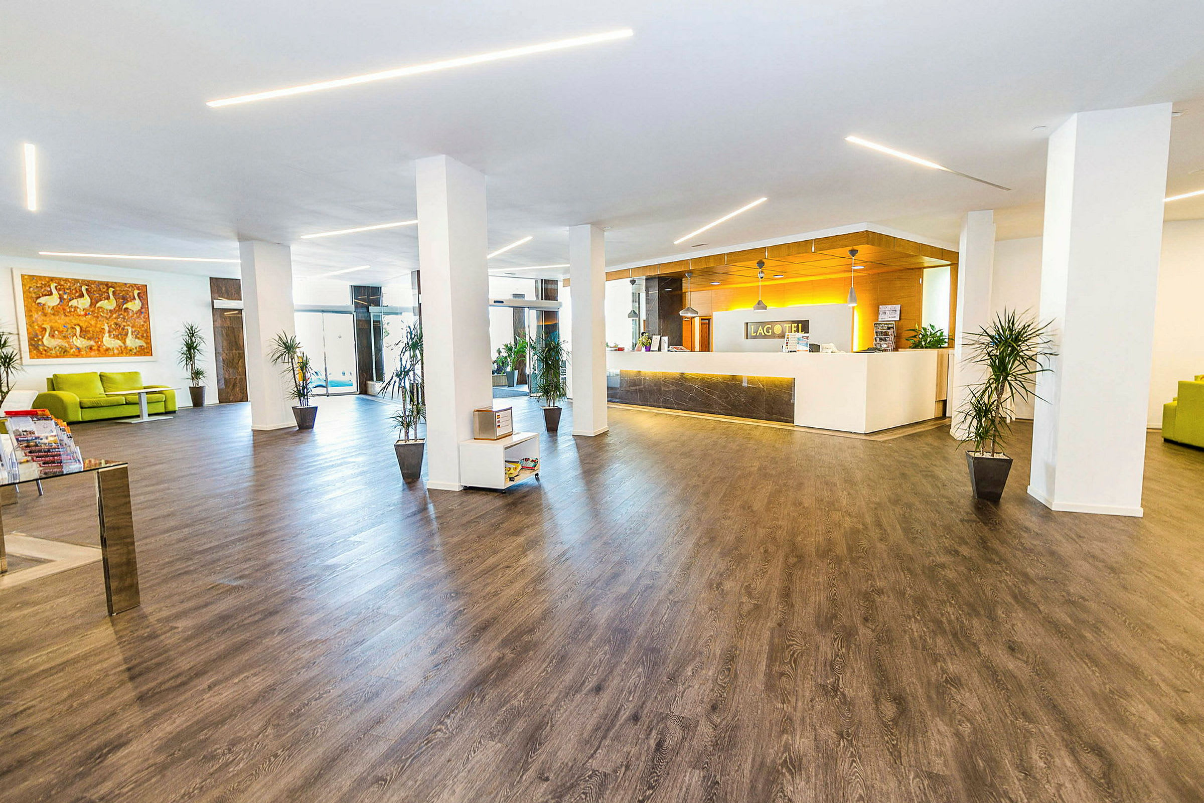 Billede af en hotellobby med moderne indretning, trægulve og en receptionsdisk. (AI-genereret tekst)