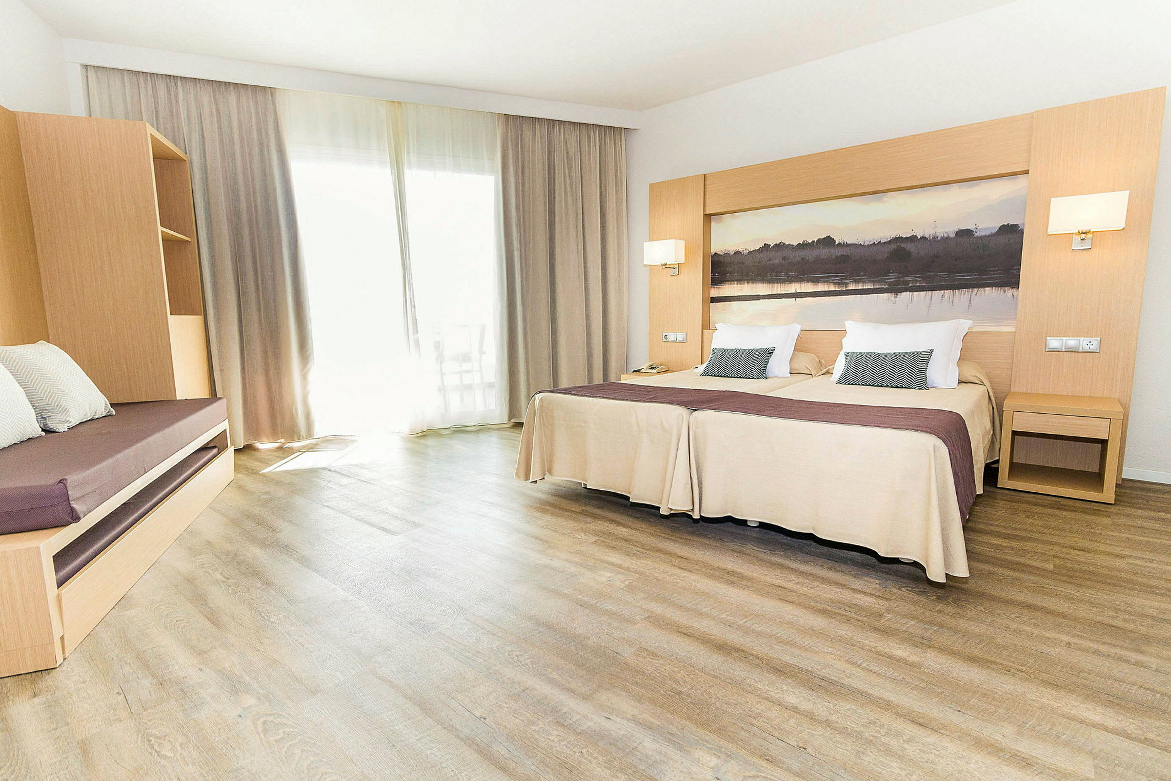 Hotelværelse med to enkeltsenge, en siddeplads og store gardiner. (AI-genereret tekst)