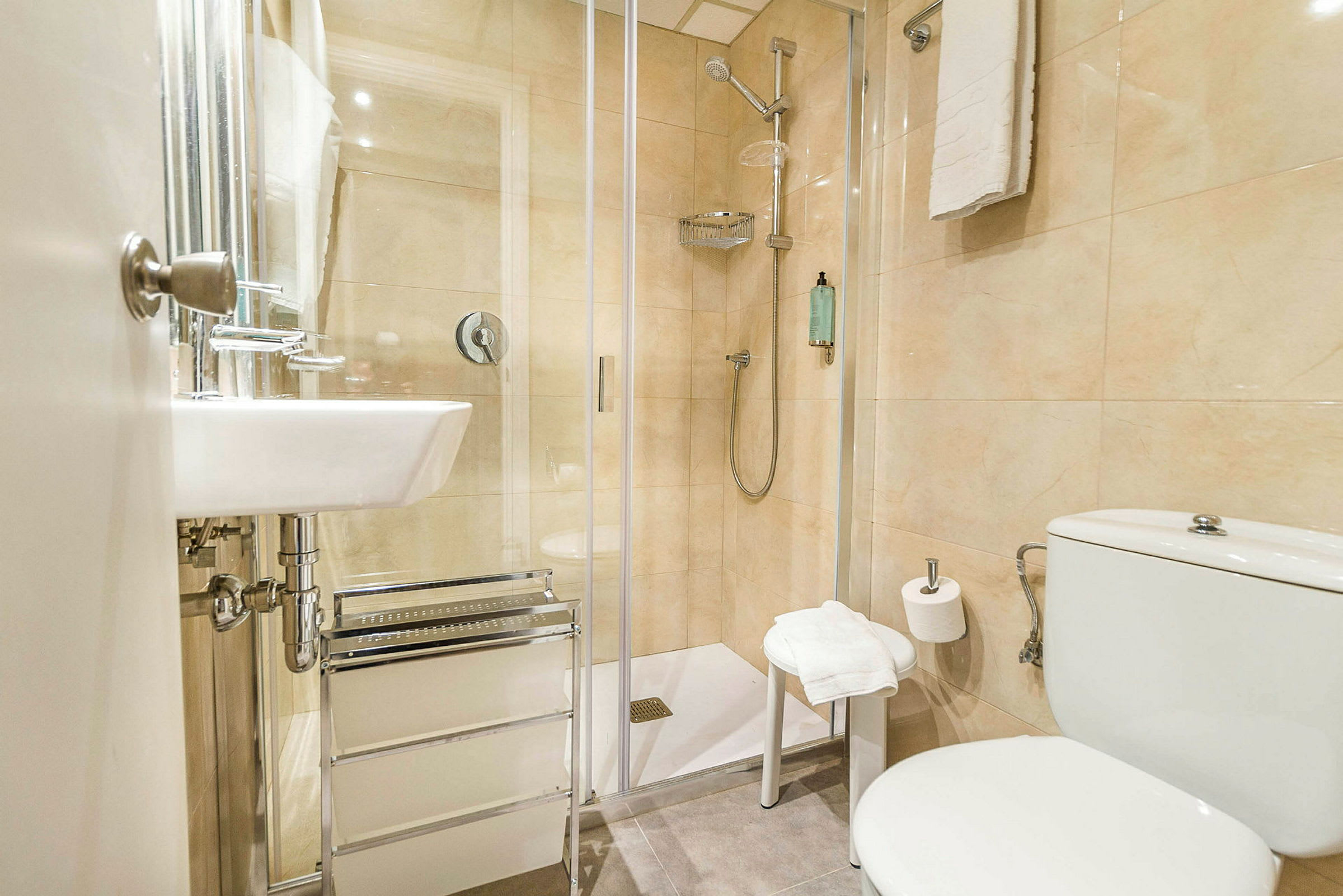 Et badeværelse med brusekabine, toilet og håndvask. (AI-genereret tekst)