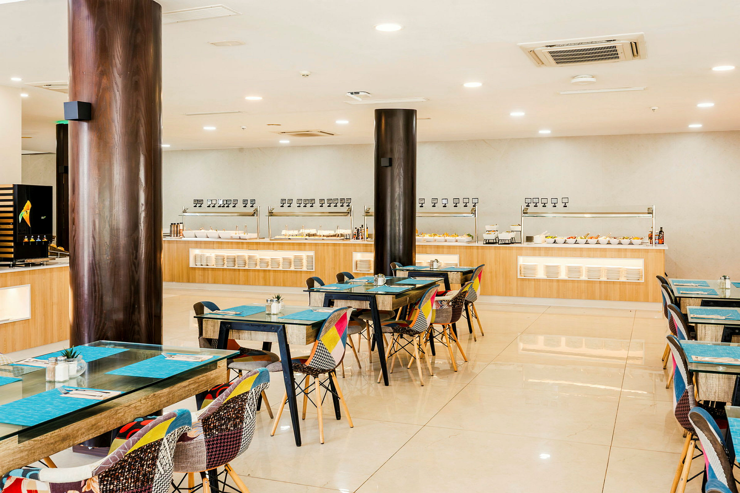 Interiør af en restaurant med borde og stole samt en buffetdisk. (AI-genereret tekst)