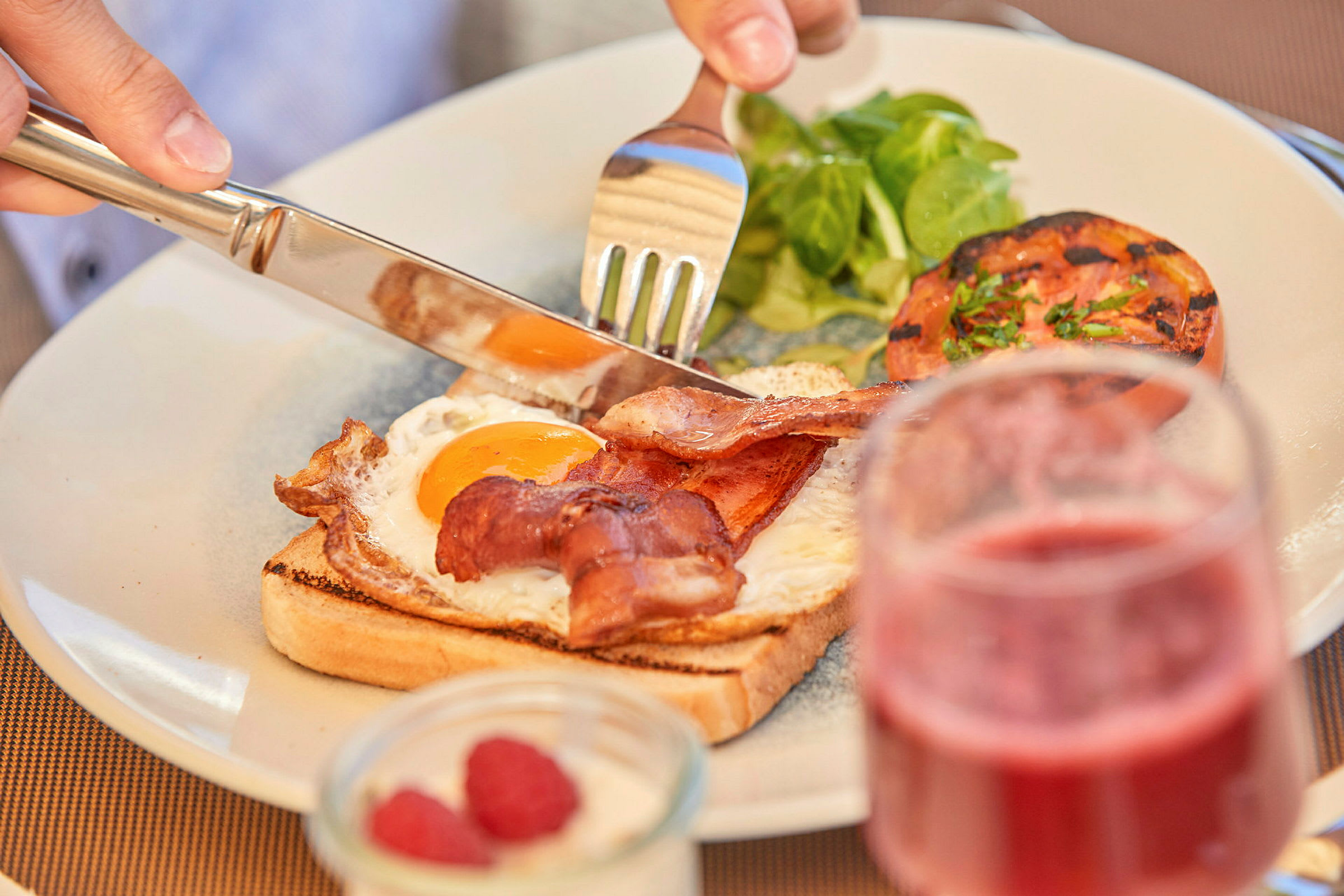 Tallerken med bacon, stegt æg og grønt. (AI-genereret tekst)